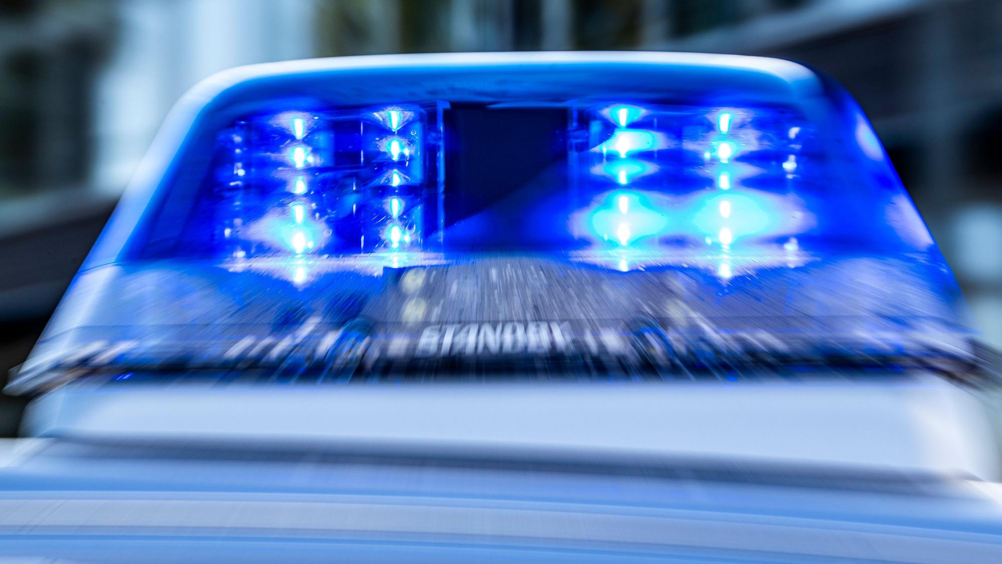 Das Blaulicht an einem Polizeiwagen ist eingeschaltet.