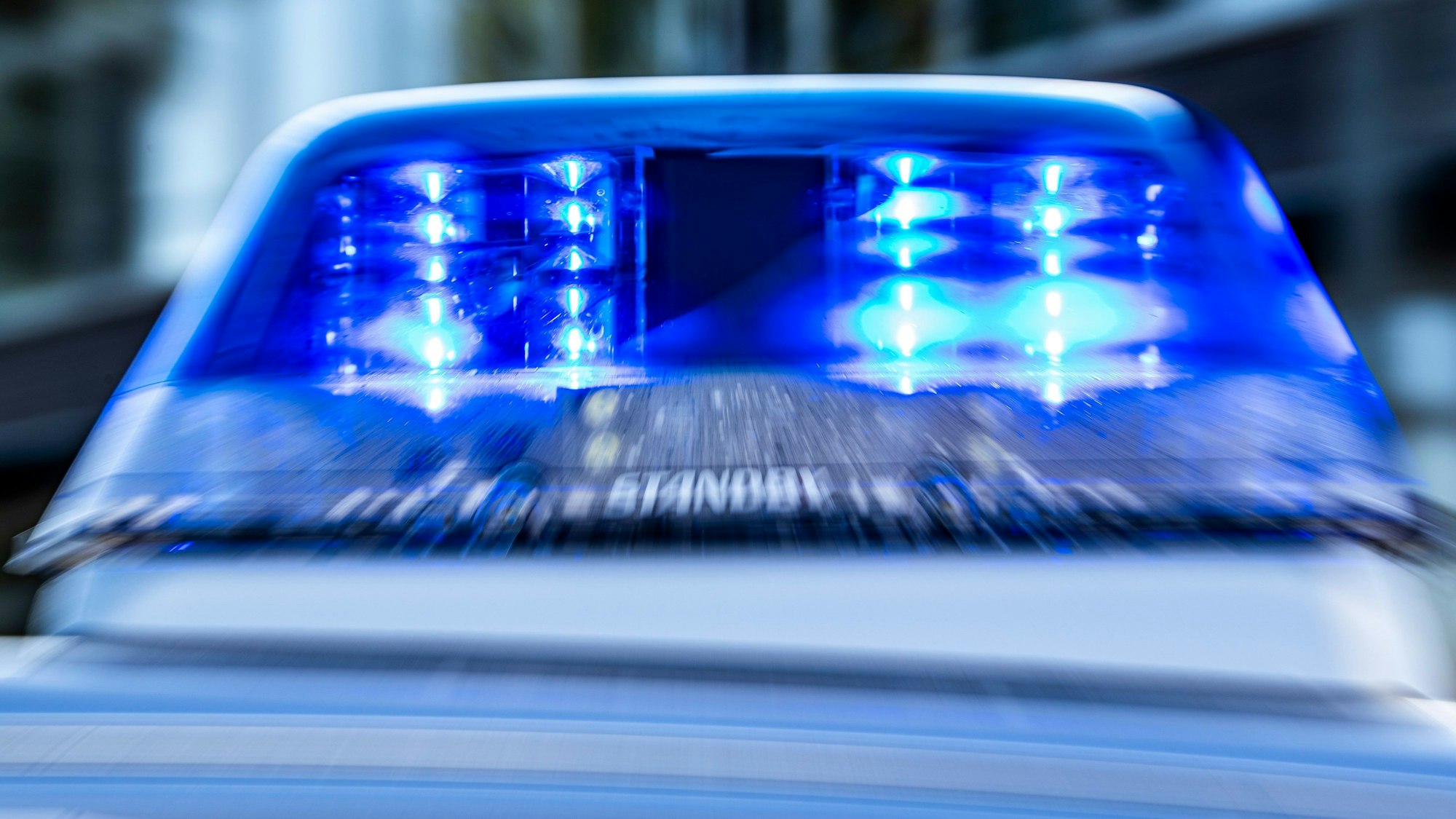 Das Blaulicht an einem Polizeiwagen ist eingeschaltet.