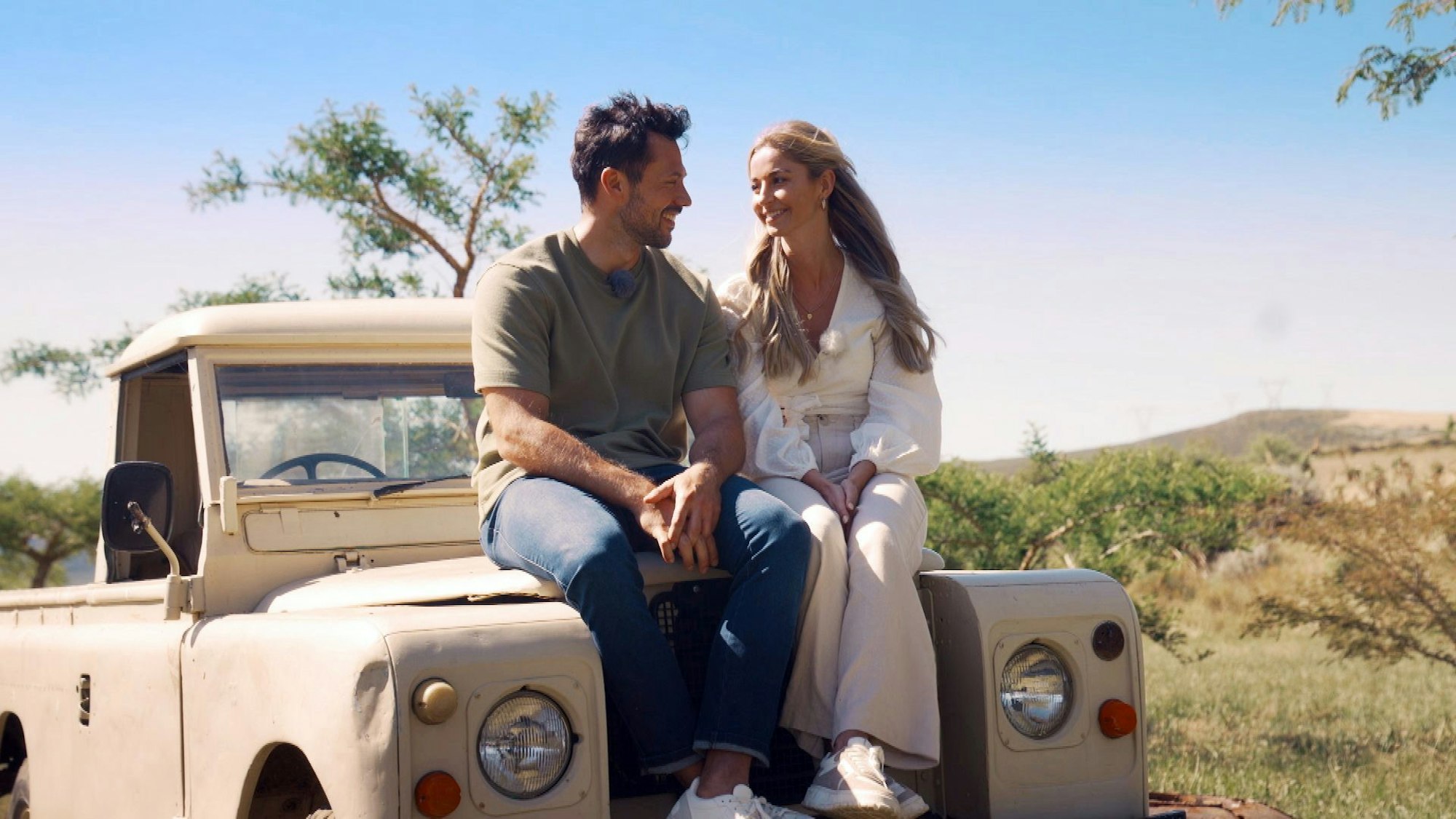 Ein Mann und eine Frau sitzen auf einem Auto.