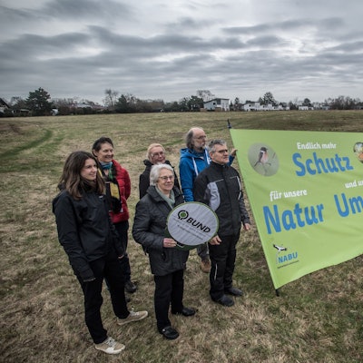 Nabu und BUND wollen lauter werden. Hier haben sie sich auf der Wiese im Kurtekotten in der Einflugschneise getroffen, um gegen das Bayer04-Haus an dieser Stelle zu protestieren.