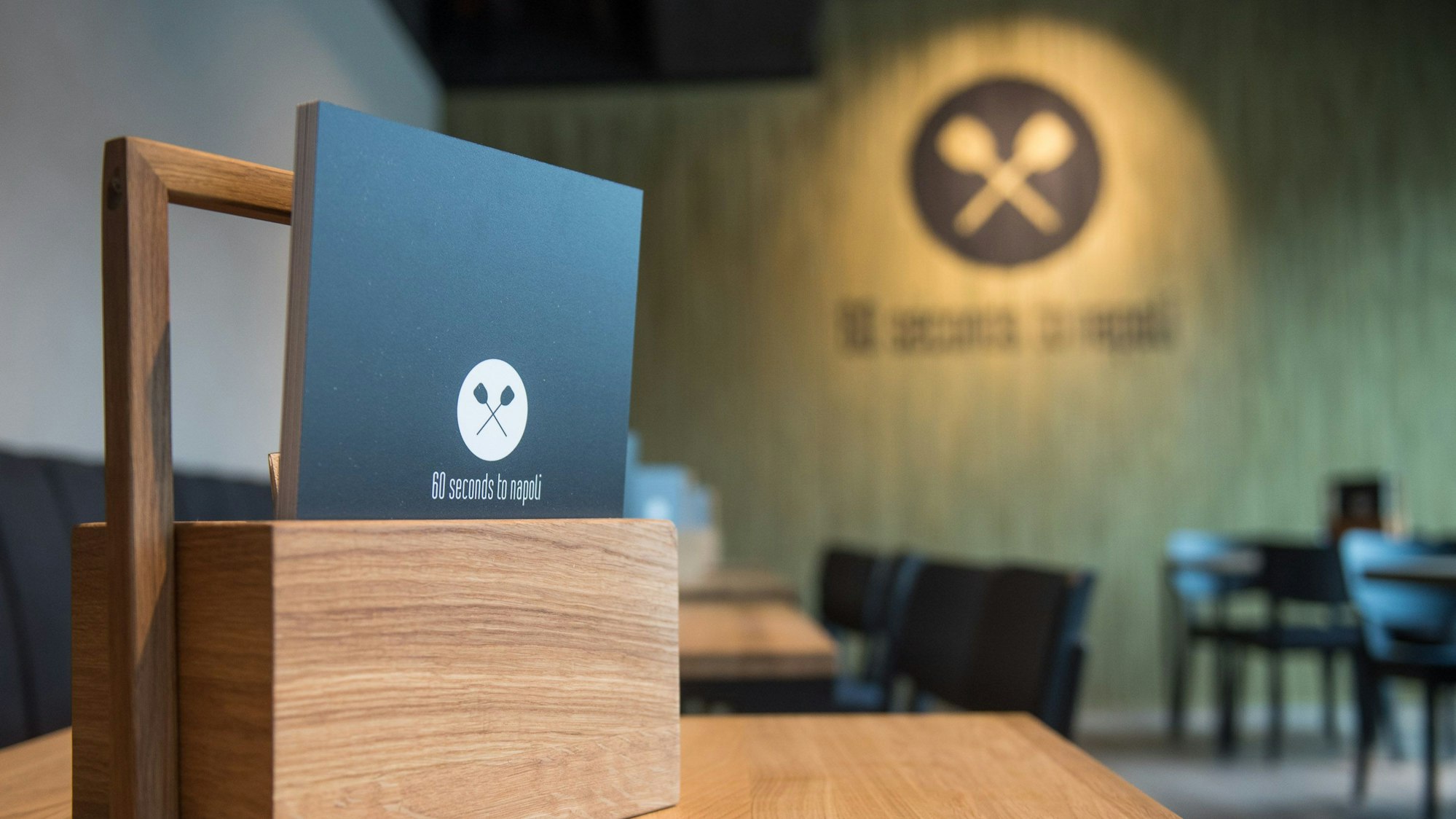 Zu sehen ist eine Speisekarte auf einem Tisch in einem Restaurant.