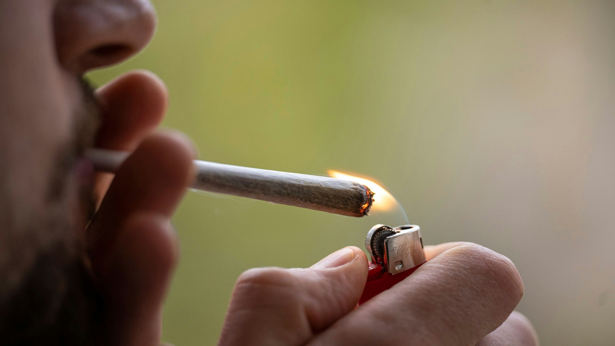 Ein Mann zündet einen Joint an.