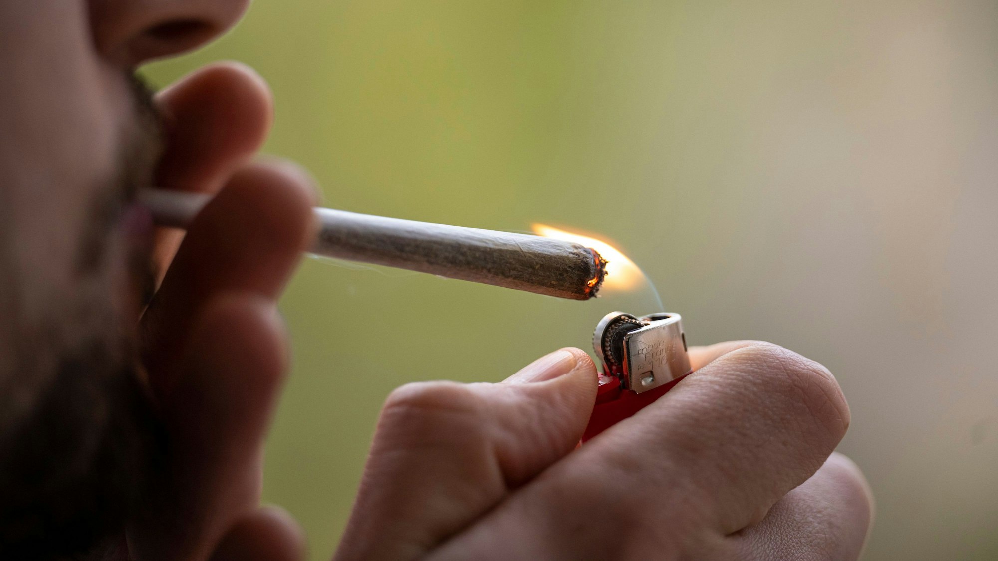 Ein Mann zündet sich einen Joint an.