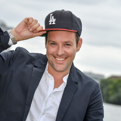 Berlin: 20.08.2018, Berlin: Ben Blümel fasst sich bei einem Pressetermin zur Vorstellung der zweiten Staffel der ProSieben-Action-Show "Global Gladiators" an die Kappe.