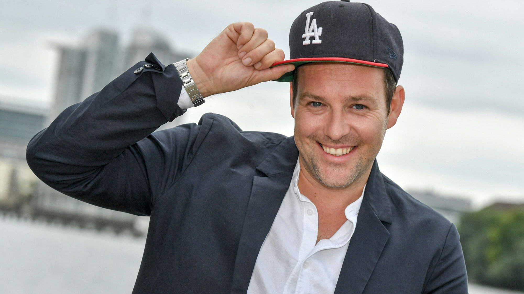 Berlin: 20.08.2018, Berlin: Ben Blümel fasst sich bei einem Pressetermin zur Vorstellung der zweiten Staffel der ProSieben-Action-Show "Global Gladiators" an die Kappe.