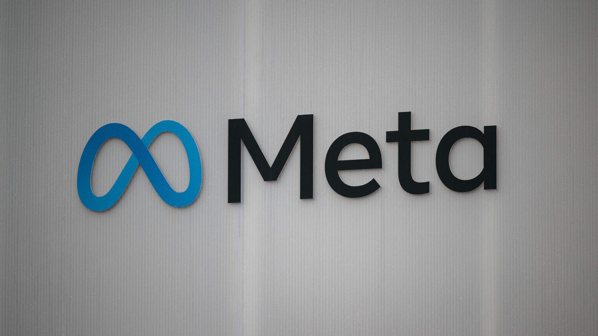 Das Firmenlogo von Meta an einer weißen Wand.