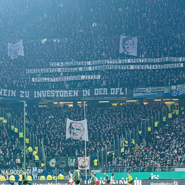 Fans von Hannover 96 zeigen ihren Geschäftsführer Martin Kind im Fadenkreuz, darüber erklären sie mit Spruchbannern die Bedeutung dieser Darstellung.