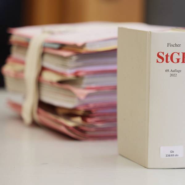 Gerichtsakten und Bücher zu Strafgesetzbuch und Strafprozessordnung liegen bzw. stehen liegen auf einem Tisch in einem Gericht.