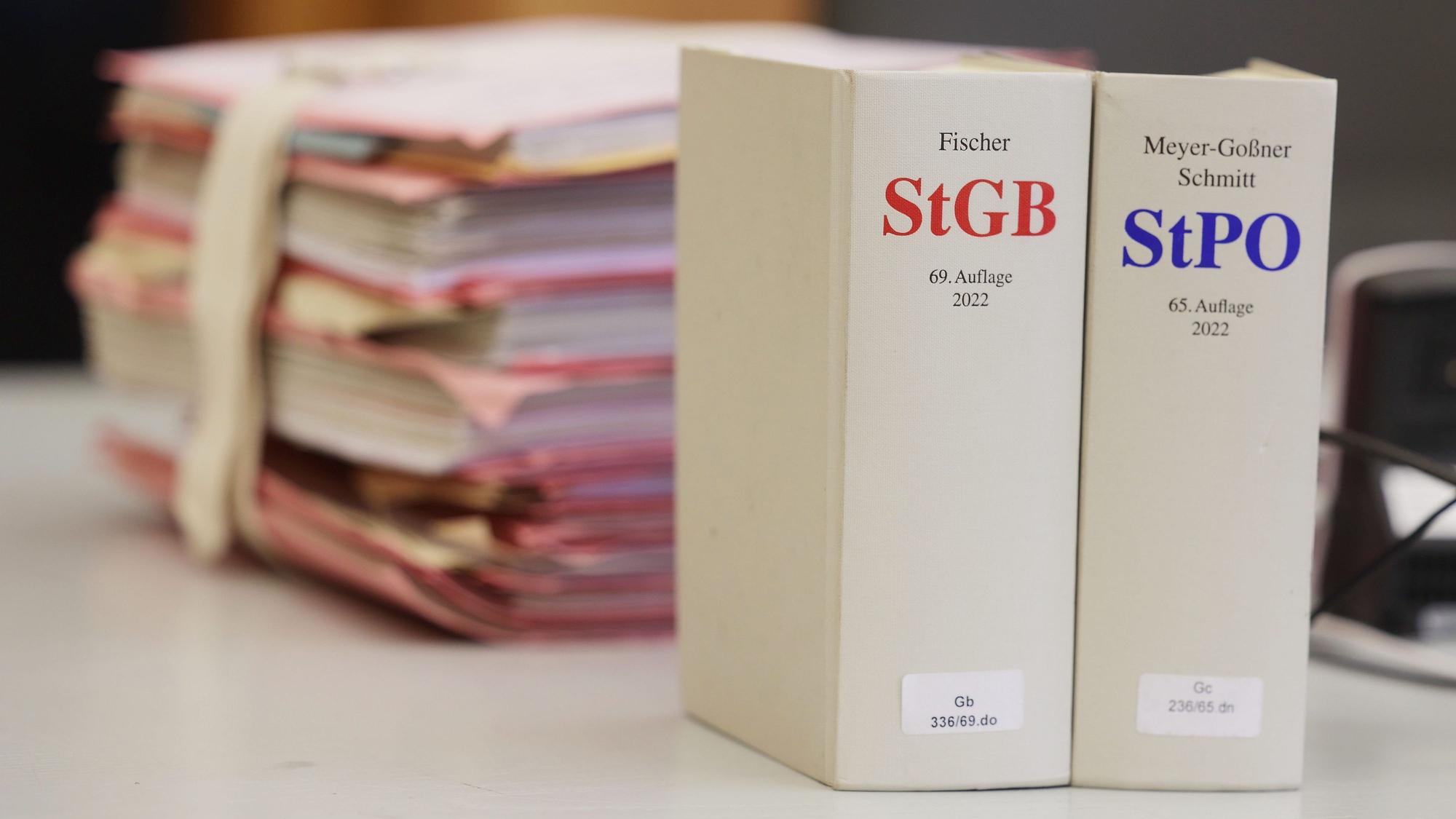 Gerichtsakten und Bücher zu Strafgesetzbuch und Strafprozessordnung liegen bzw. stehen liegen auf einem Tisch in einem Gericht.