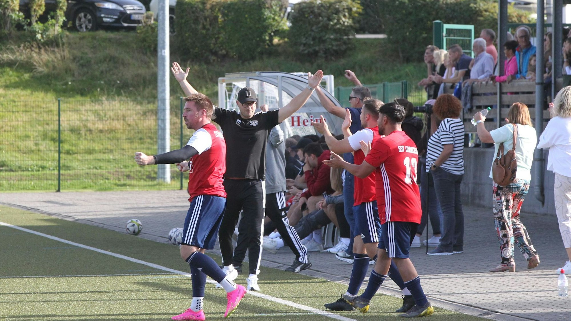 Philipp Henn und einige seiner Spieler jubeln. Im Hintergrund das Publikum in Dahlem.