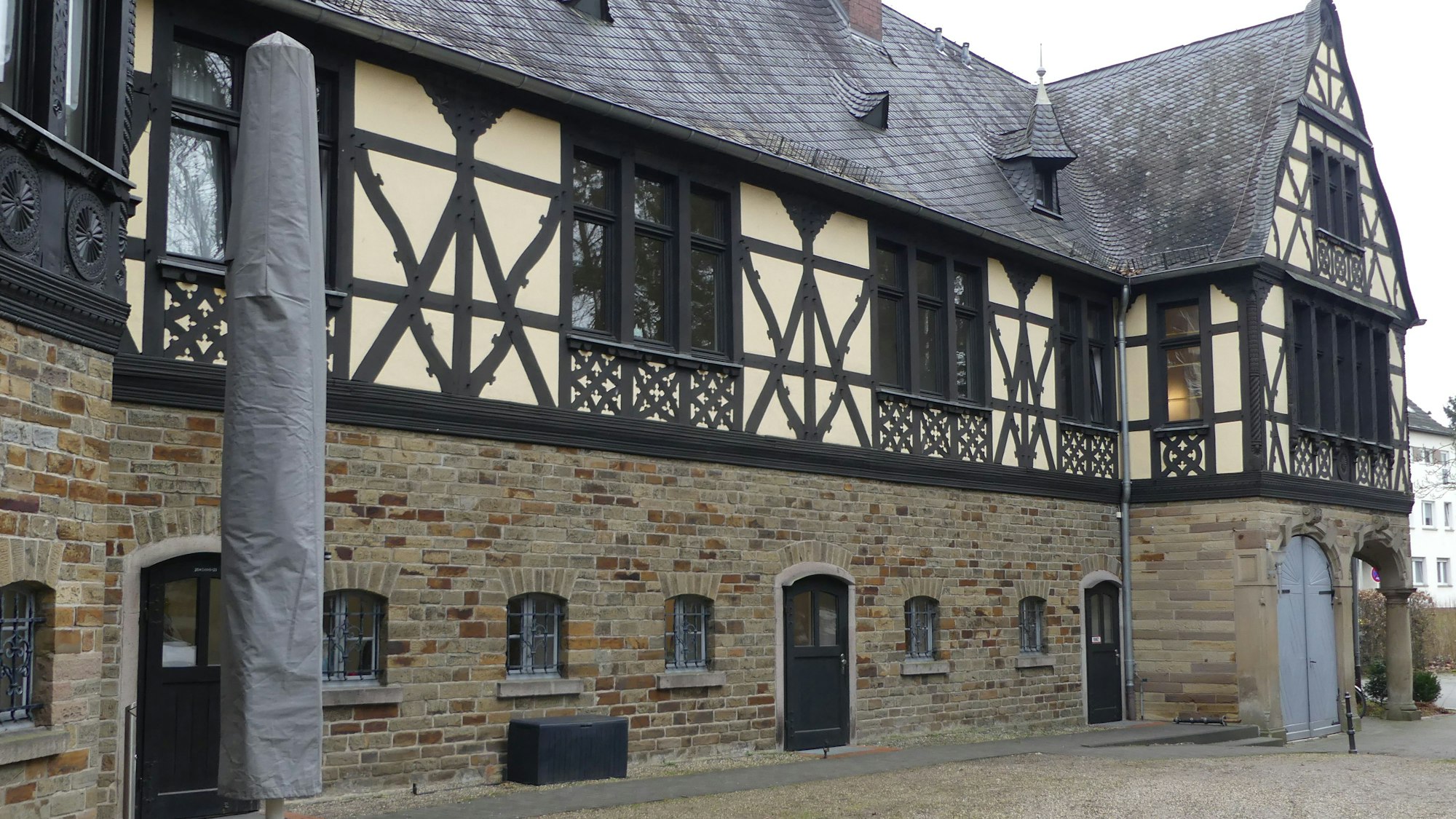 Ein verschnörkeltes Fachwerkhaus mit einem Sockel aus Stein.