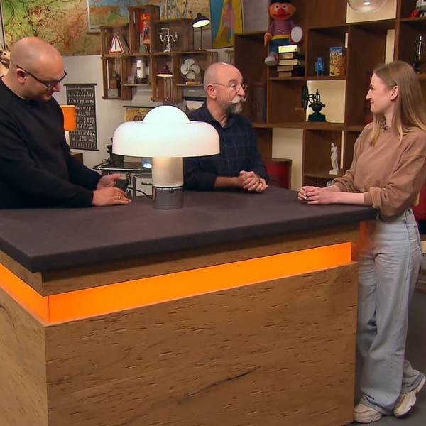 Experte Sven Deutschmanek (l.) nimmt bei „Bares für Rares“ die außergewöhnliche Lampe unter die Lupe. Horst Lichter (M.) staunte nicht schlecht über die Geschichte von Caroline Sauer (r.) aus Frechen.