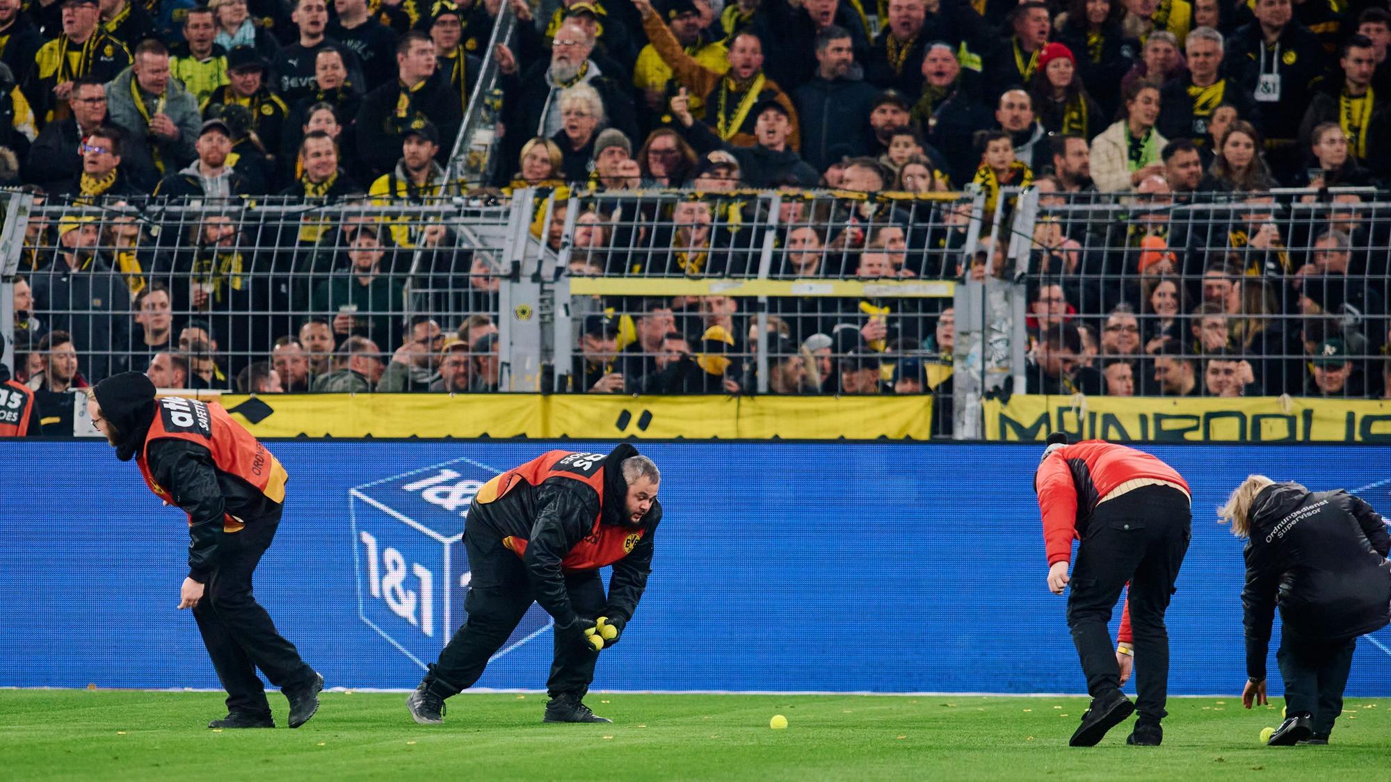 Stadionmitarbeiter sammeln Tennisbälle ein im Spiel des BVB gegen Freiburg
