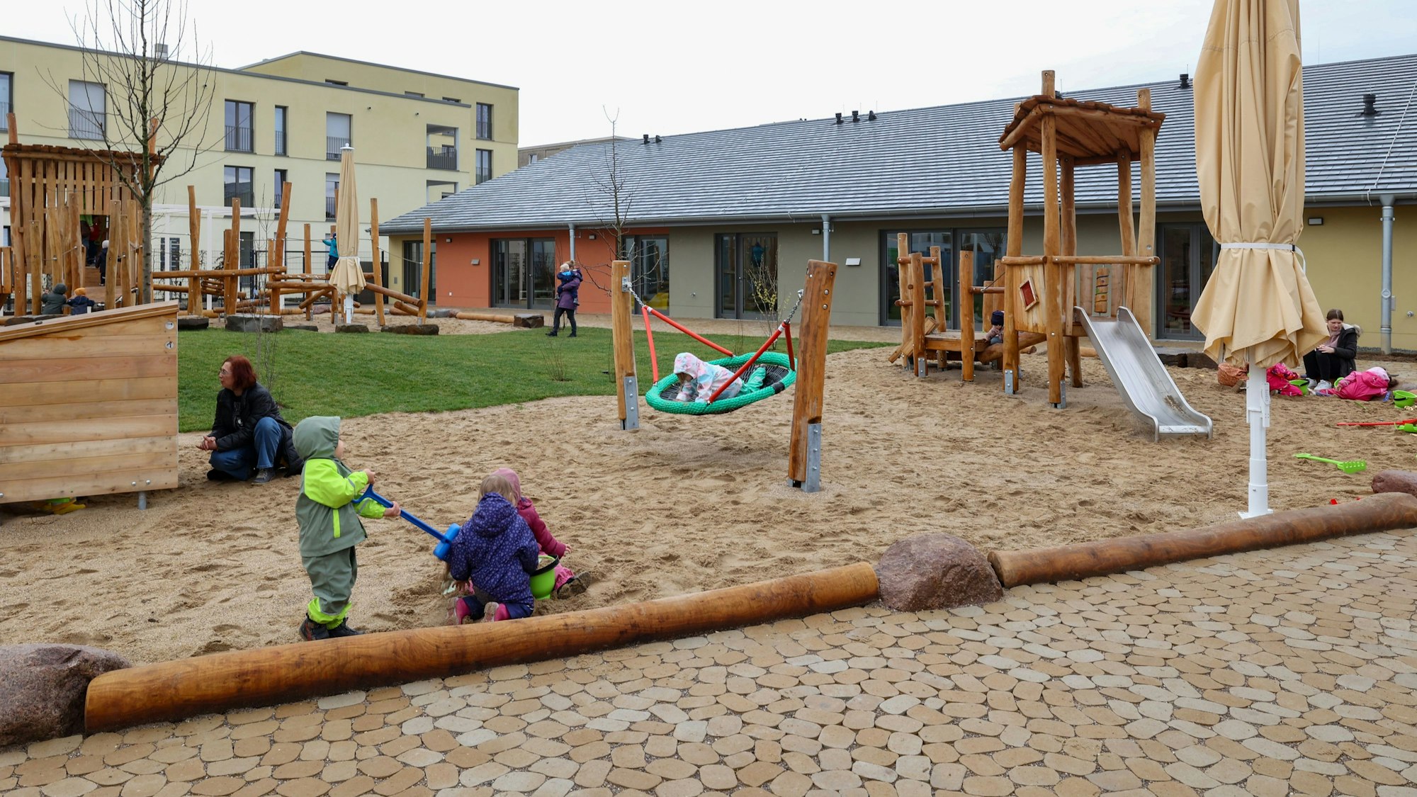 Kinder spielen auf dem Außengelände einer Kindertagesstätte.