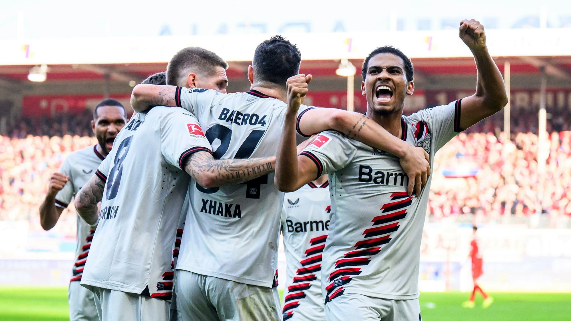 Leverkusens Frimpong (verdeckt) jubelt nach seinem Tor zum 0:1 mit der Mannschaft und Leverkusens Amine Adli (r).