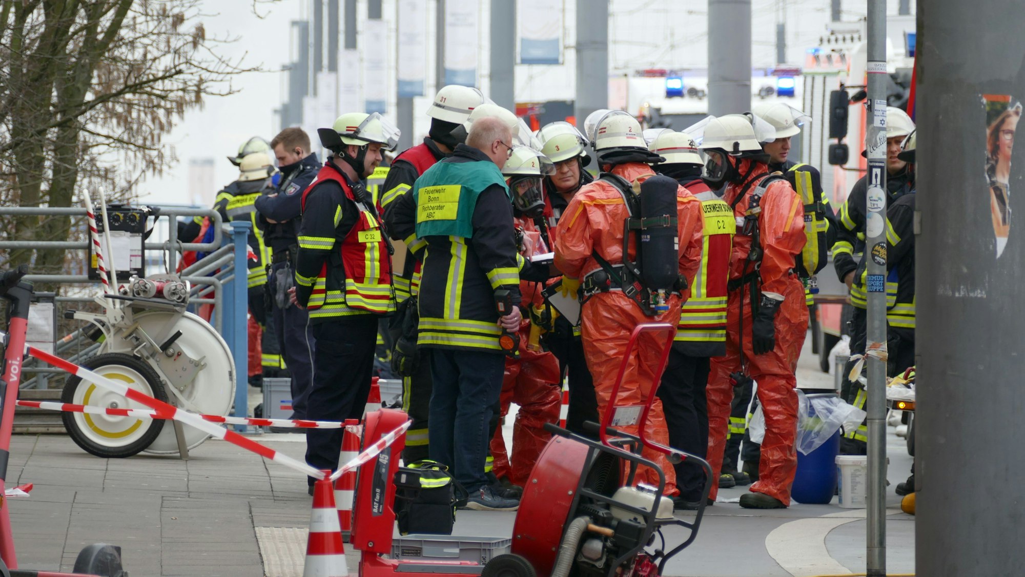 Feuerwehrleute in Schutzanzügen erkunden die Lage am Brückenforum in Bonn.