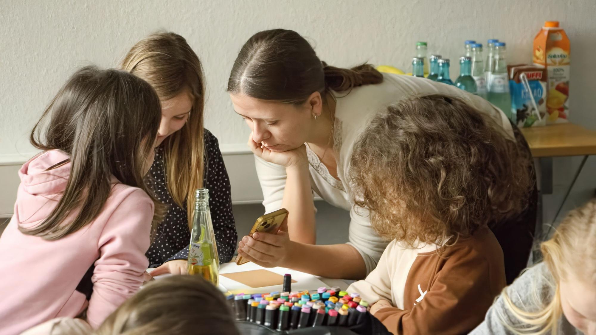 Im Fluthilfebüro des Caritasverbandes Euskirchen malen Kinder mit Saskia Reder.