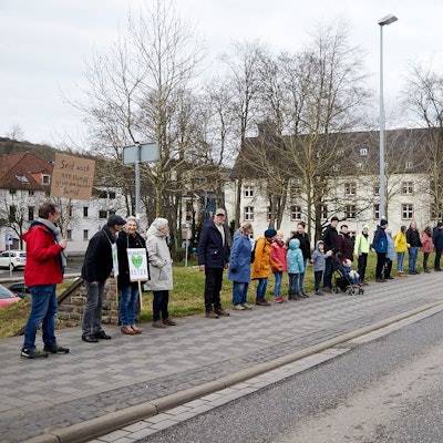 Teilnehmer einer Menschenkette zwischen Verteilerkreis und Olefbrücke in Schleiden. Einige haben Plakate dabei.
