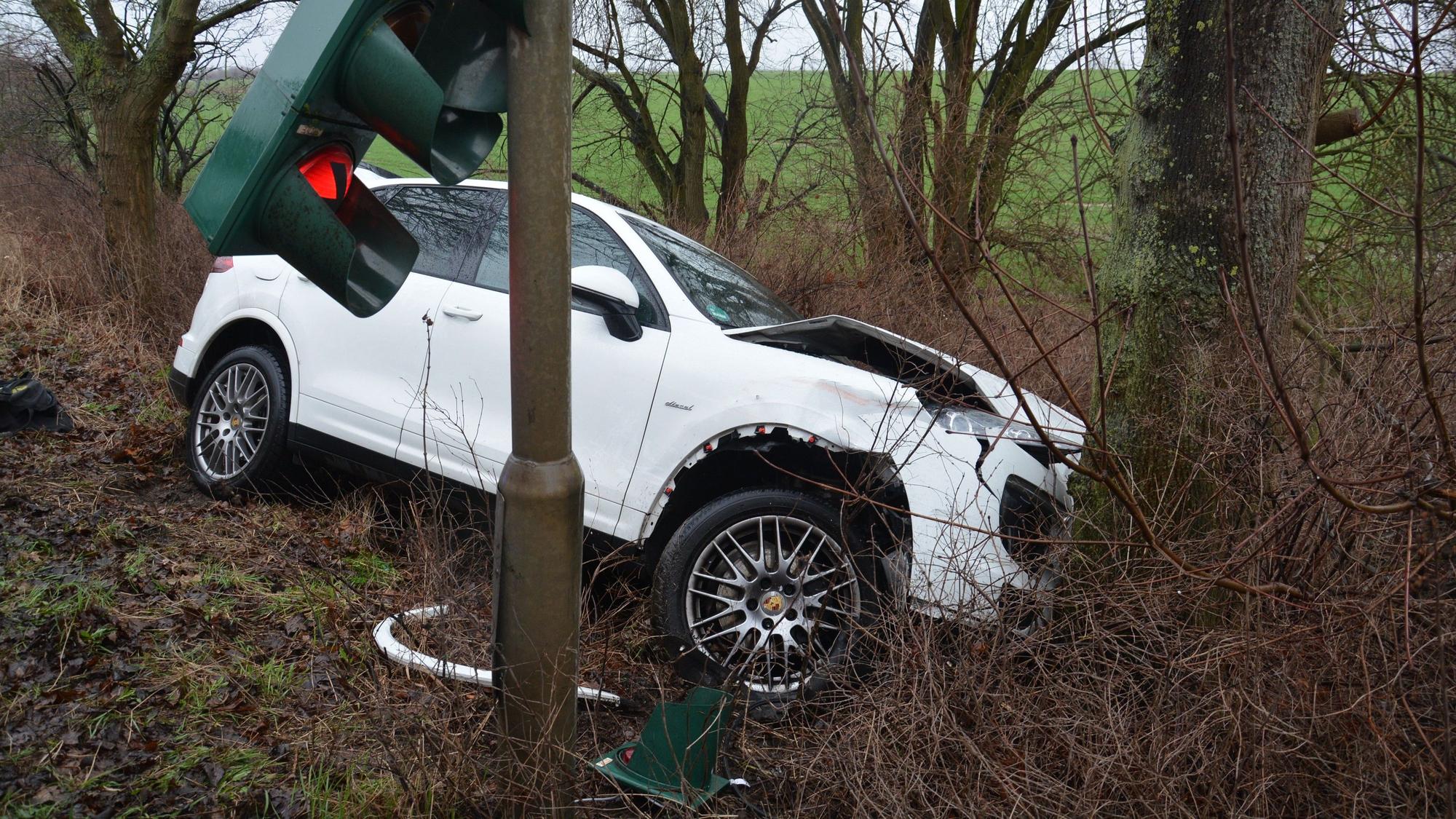 Ein Wagen liegt nach einem Unfall seitlich in einer Böschung.