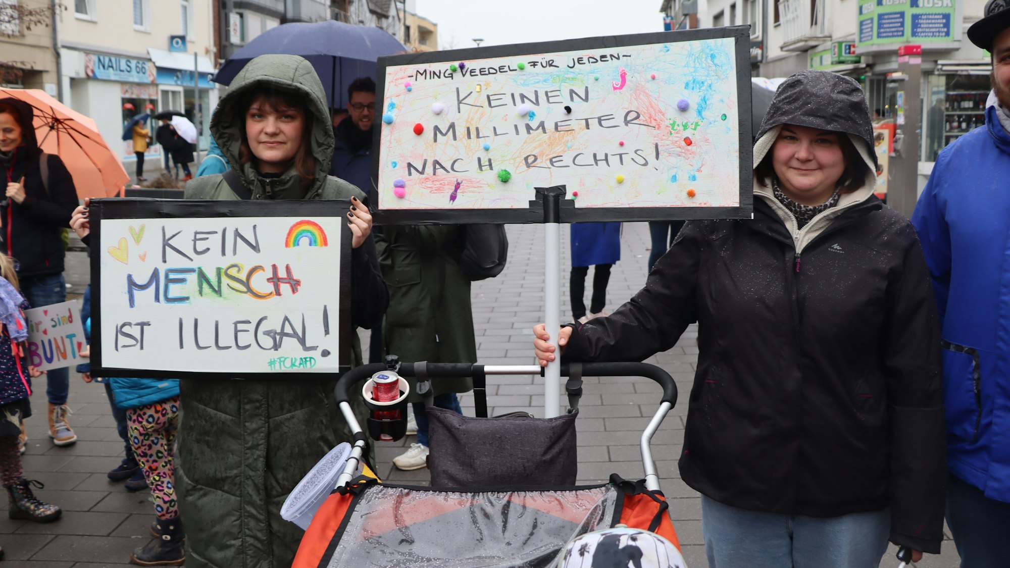 Auf dem Foto sind Teilnehmerinnen der Demonstration mit selbst gebastelten Plakaten zu sehen.
