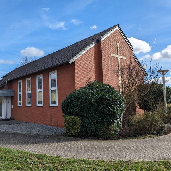 Die kleine Neuapostolische Kirche mit großem Kreuz an der Giebelwand und dem neugestalteten Eingangsbereich.