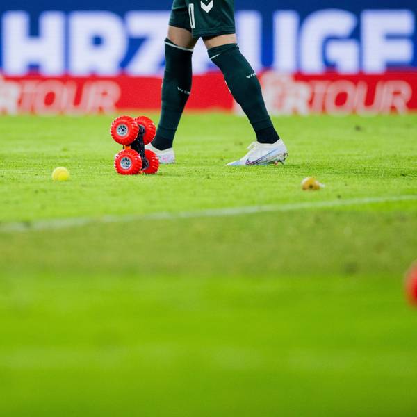Ferngelenkte Autos fahren beim Heimspiel des 1. FC Köln gegen Werder Bremen auf dem Spielfeld im Rhein-Energie-Stadion neben Tennisbällen umher.