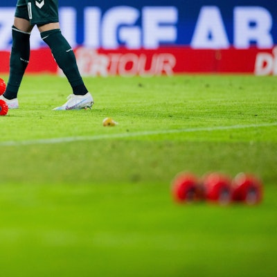 Ferngelenkte Autos fahren beim Heimspiel des 1. FC Köln gegen Werder Bremen auf dem Spielfeld im Rhein-Energie-Stadion neben Tennisbällen umher.