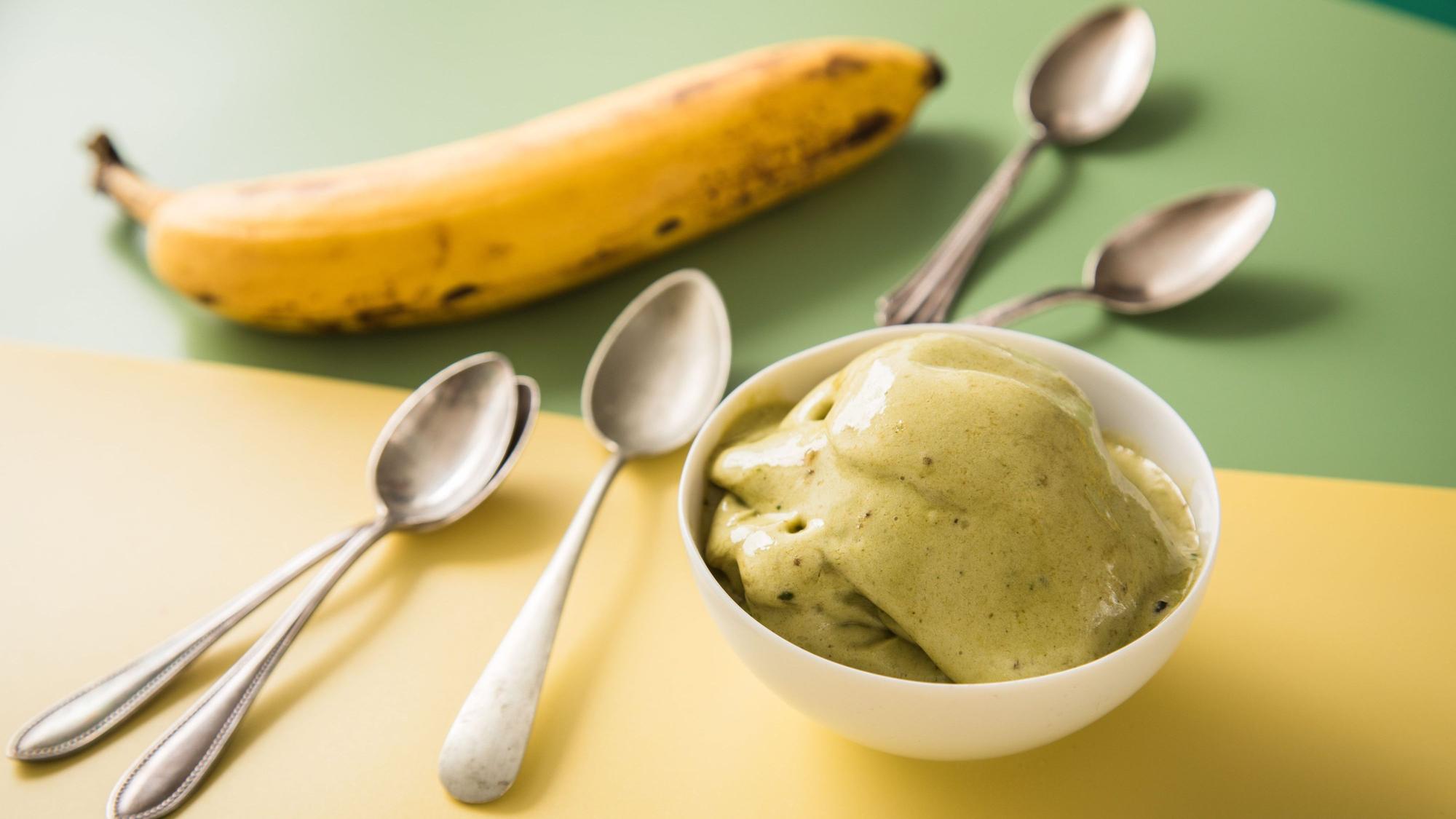 Matcha-Nice Cream in einer Schale, daneben kleine Löffel und eine Banane