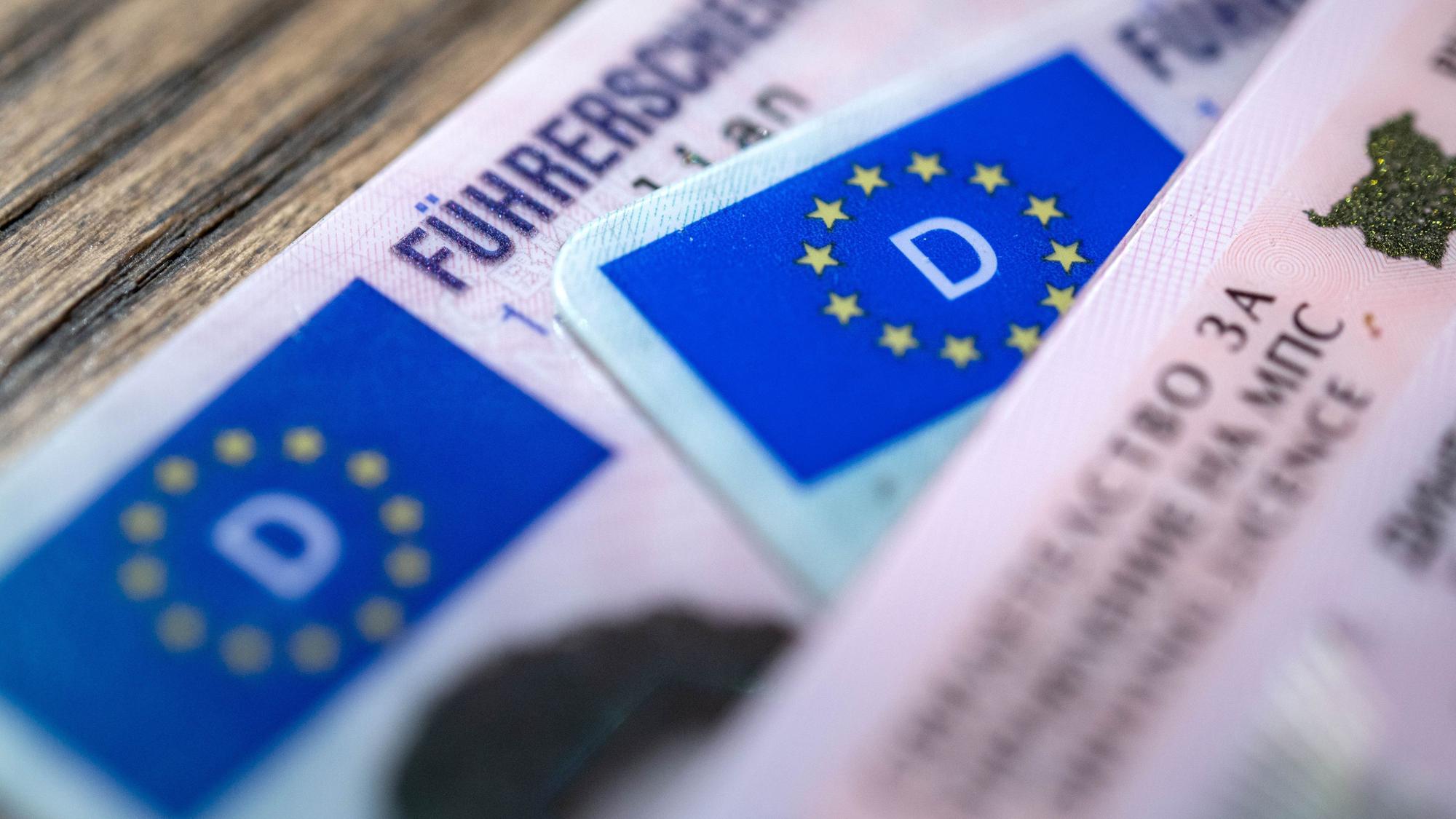 ARCHIV - 06.12.2023, Bremen: ILLUSTRATION - Ein bulgarischer und zwei deutsche Führerscheine liegen auf einem Tisch. Der Verkehrsausschuss im EU-Parlament stimmt über Vorschläge zu neuen EU-Führerscheinregeln ab. (zu dpa: «EU-Parlament stimmt Position zu EU-weitem Führerscheinentzug ab») Foto: Sina Schuldt/dpa +++ dpa-Bildfunk +++