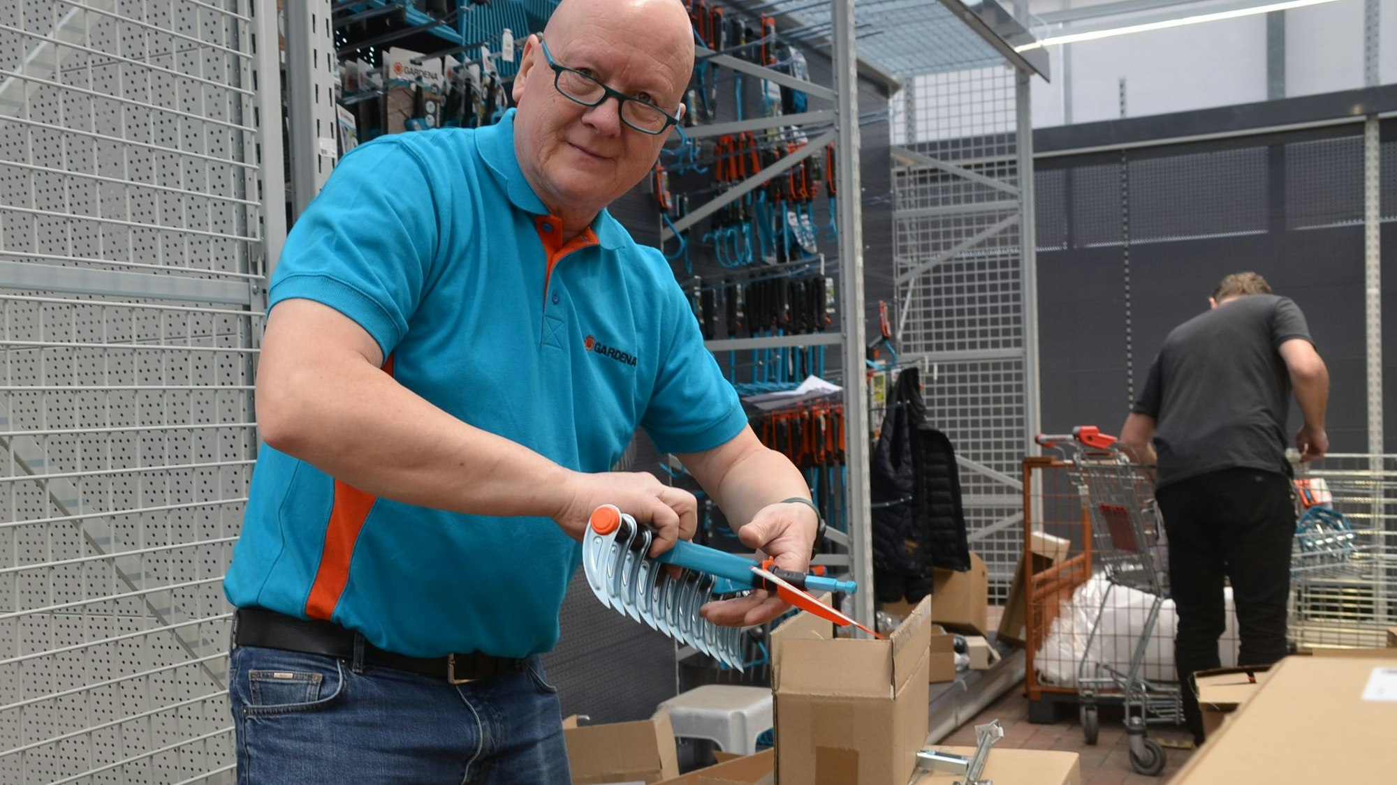 Im Waldbröler Baucentrum Cronrath wird zurzeit alles umgeräumt und neu sortiert, etwa in der Gartenabteilung. Dort räumen die Mitarbeitenden eines Herstellers für Gartengerät gerade Waren in die neuen Regale.