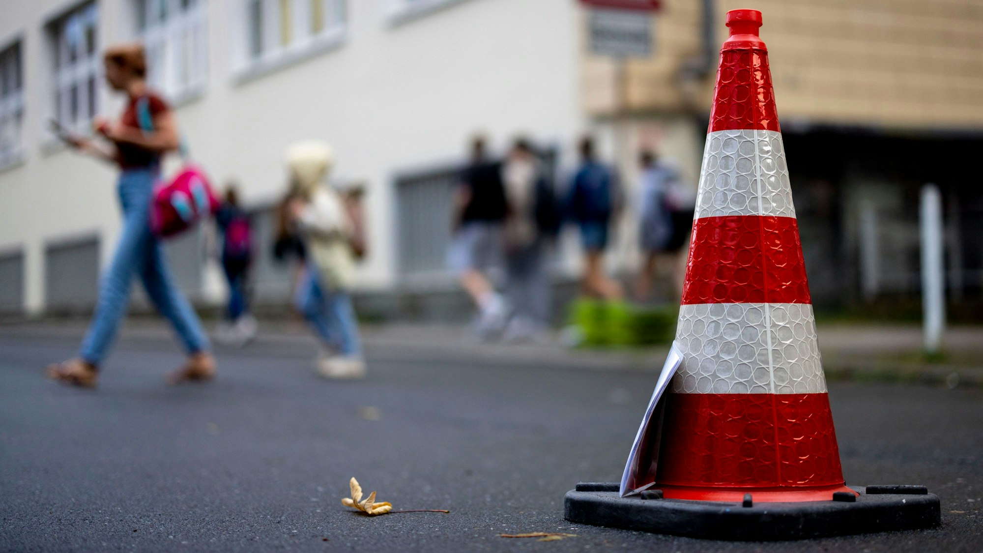 Pylonen stehen auf der Straße an der Bardelebenschule, ab 7.45 Uhr ist das Befahren der Straße für 45 Minuten untersagt, die Schüler kommen zu Fuß über den Gehweg. (zu dpa: «NRW-Kommunen können Straßen vor Schulen zeitweise sperren») Foto: Christoph Reichwein/dpa +++ dpa-Bildfunk +++