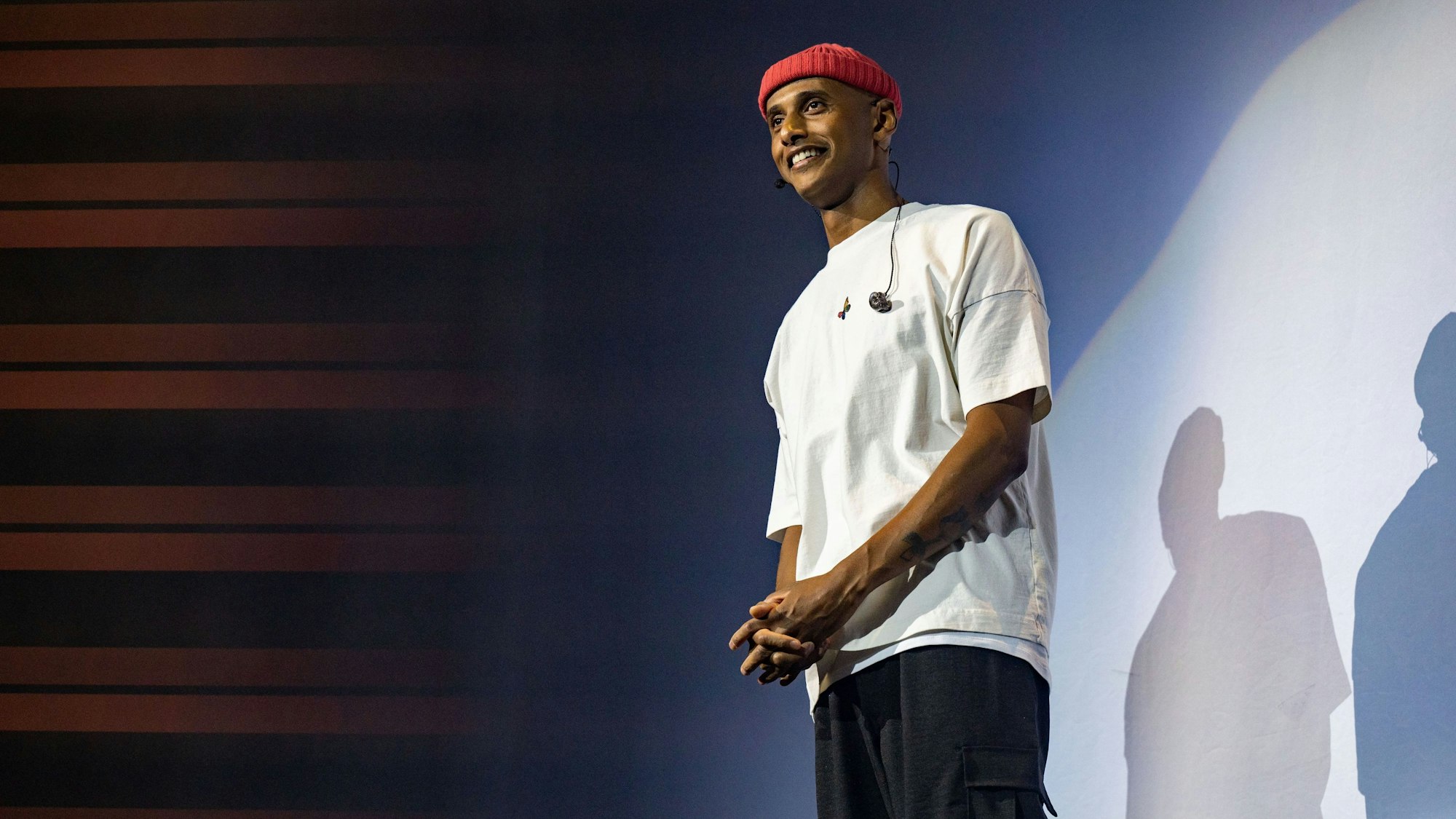 Teddy Teclebrhan steht auf einer Bühne.
