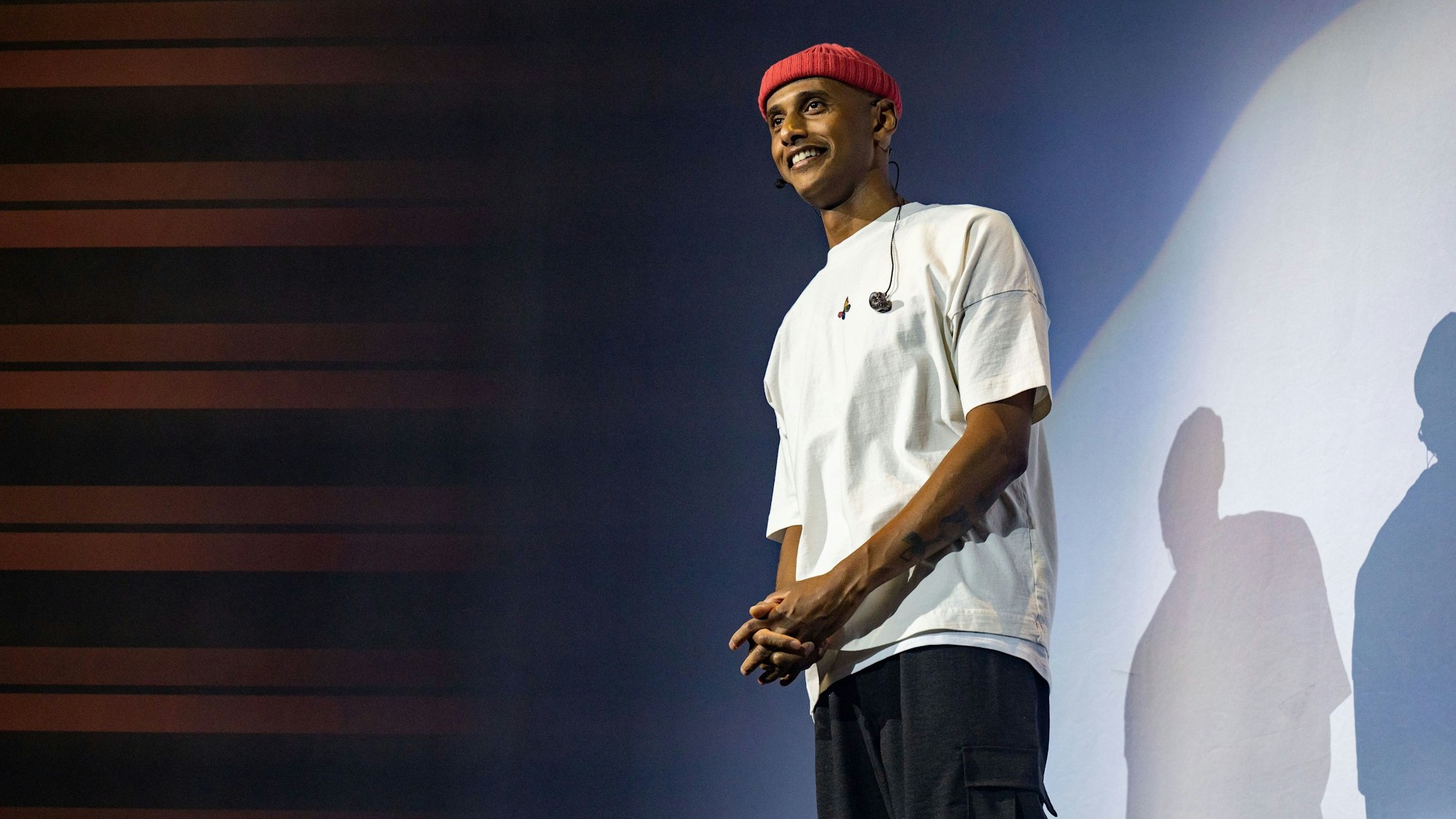 Teddy Teclebrhan steht auf einer Bühne.