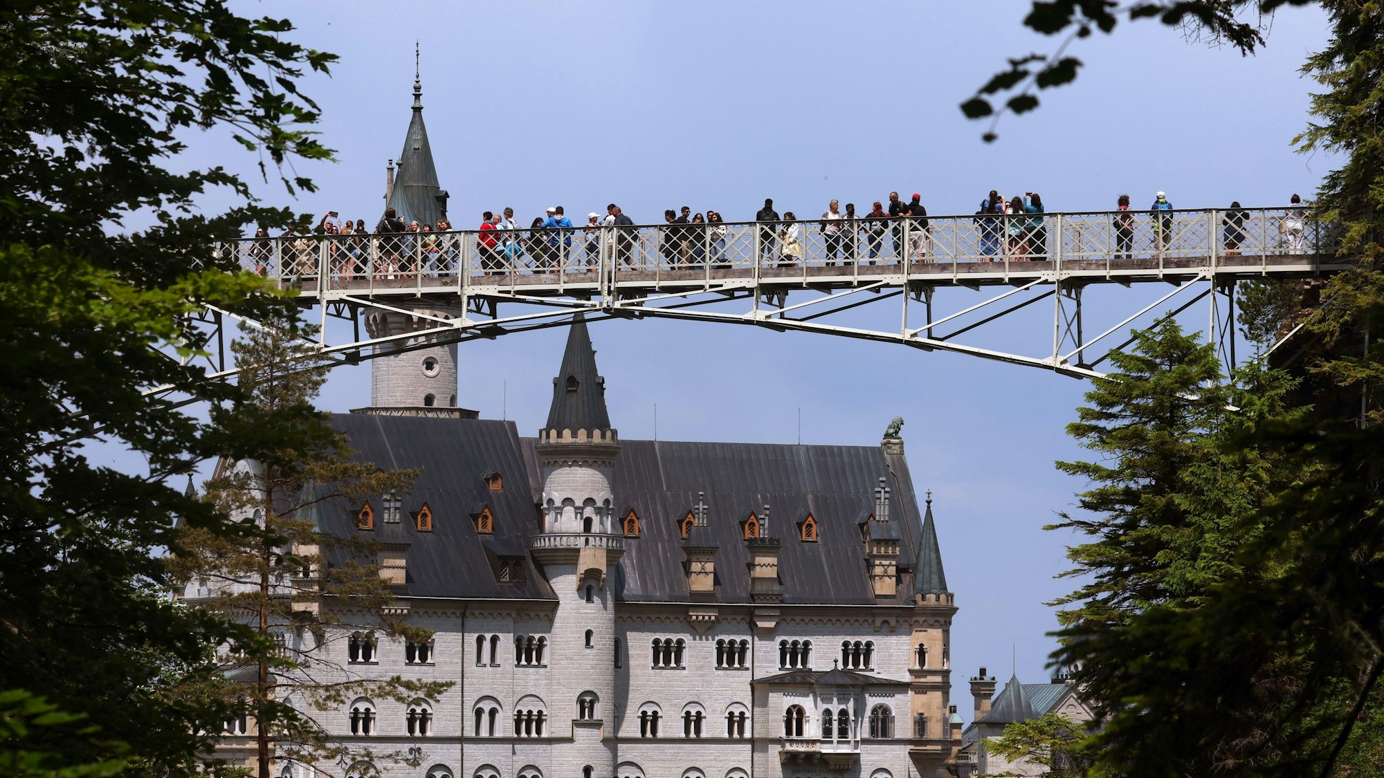 Touristen stehen auf der Marienbrücke vor dem Schloss Neuschwanstein.