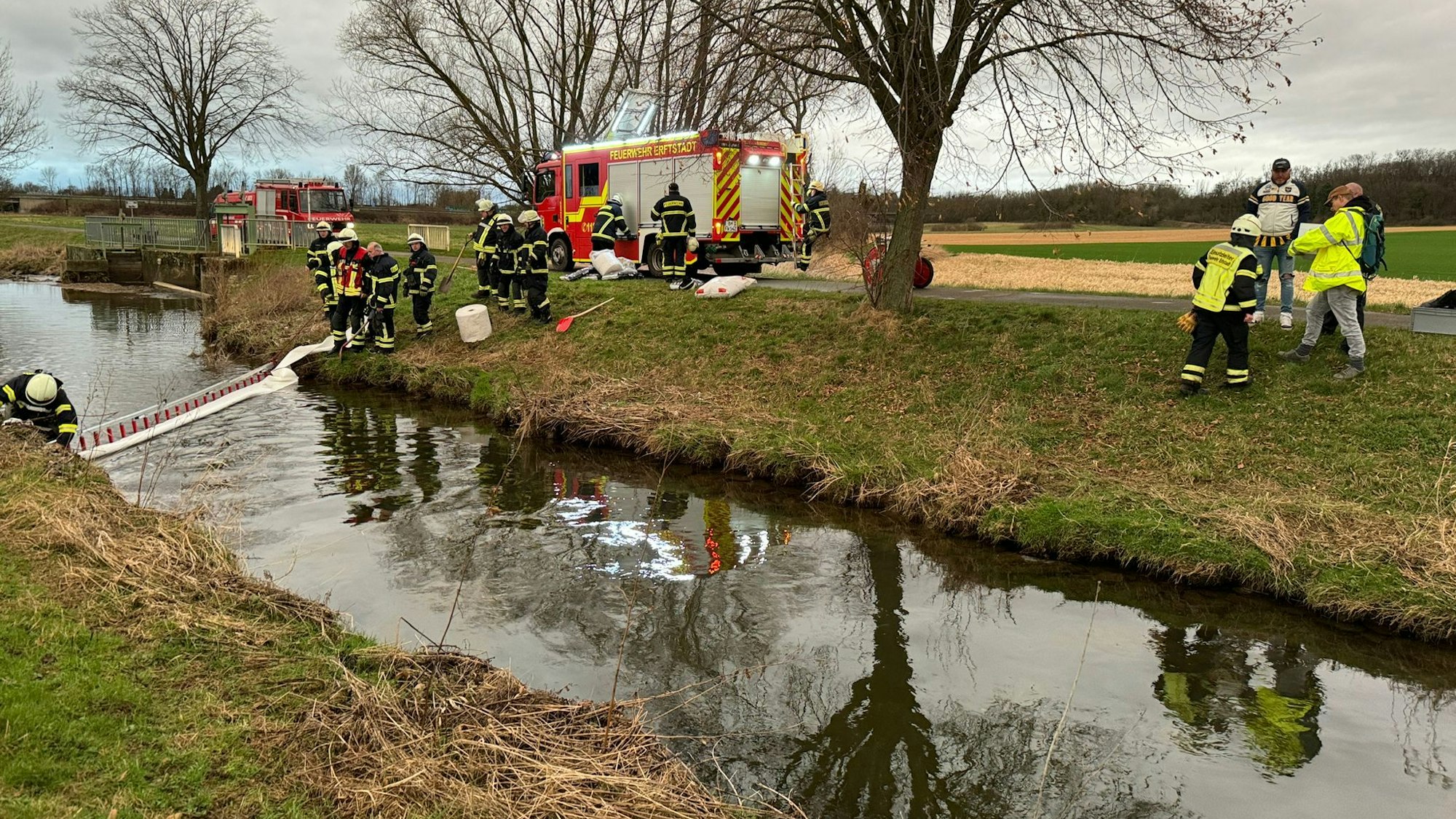Über die gesamte Breite der Swist haben Feuerwehrleute die Ölschlänger ausgebreitet.