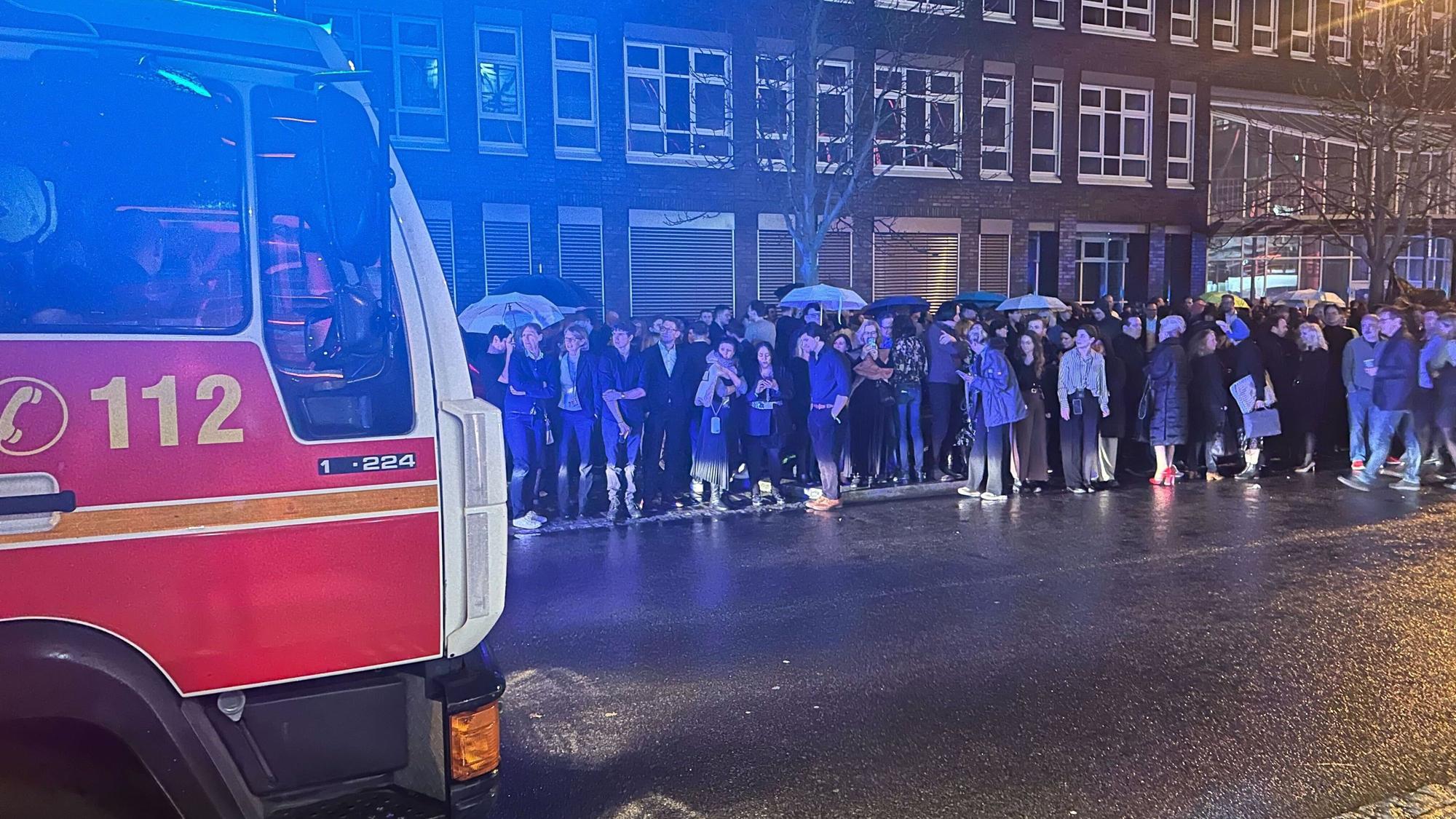 Berlin: Gäste des NRW-Empfangs im Rahmen der diesjährigen Berlinale stehen hinter einem Feuerwehrwagen auf der Straße und einem Gehweg. Ein Feueralarm hatte die Partygäste am Sonntagabend vor das Gebäude der Landesvertretung in Berlin getrieben. Die 74. Internationalen Filmfestspiele Berlin finden vom 15. bis 25.02.2024 statt.