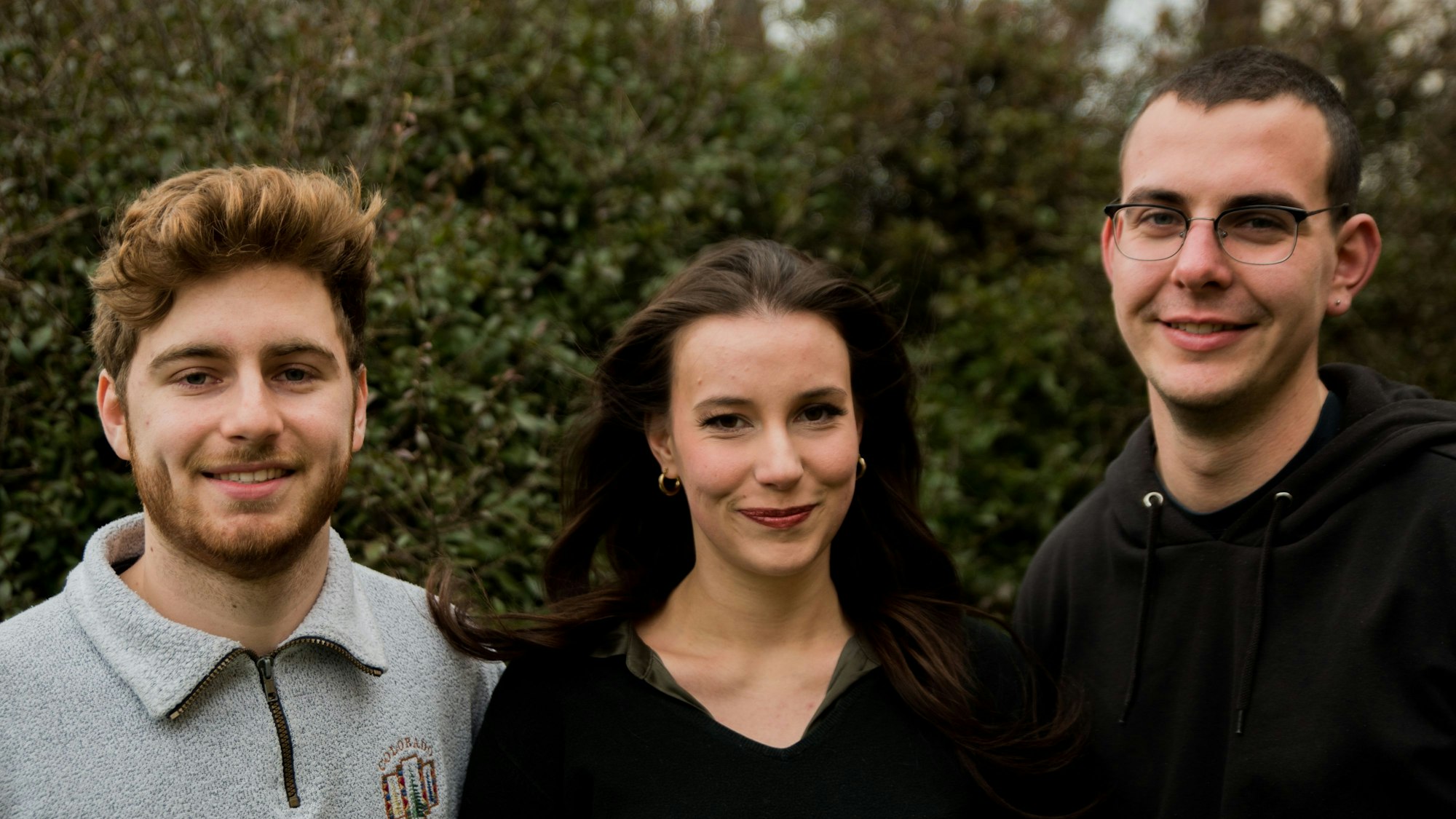 Drei Menschen stehen vor Gebüsch. V.l.n.r.: Luca Kommerell, Dominique Reich, Adrian Moser.