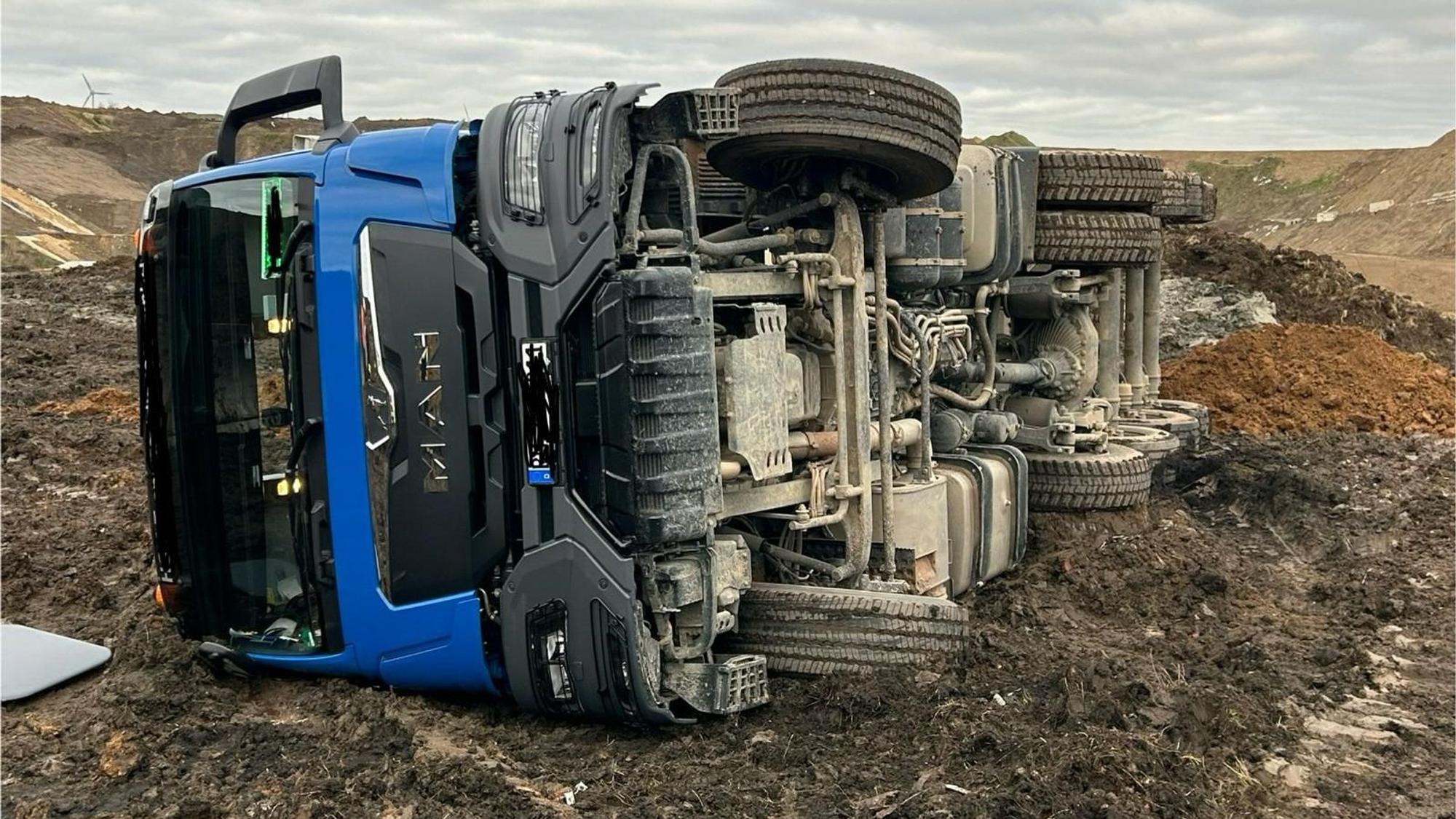Auf dem Foto ist der umgekippte blaue Sattelschlepper zu sehen.
