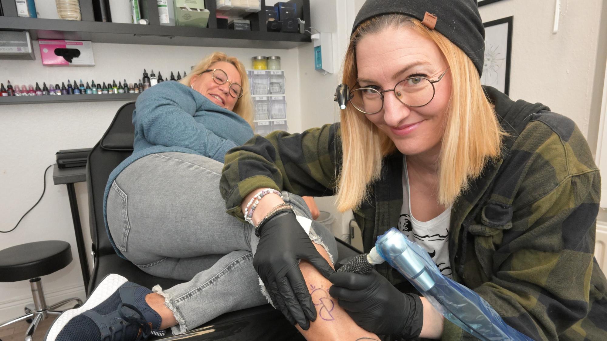 Die Tattoo-Künstlerin Rebekka Behr sticht Anja Schwerm das Organspende-Symbol unter die Haut.