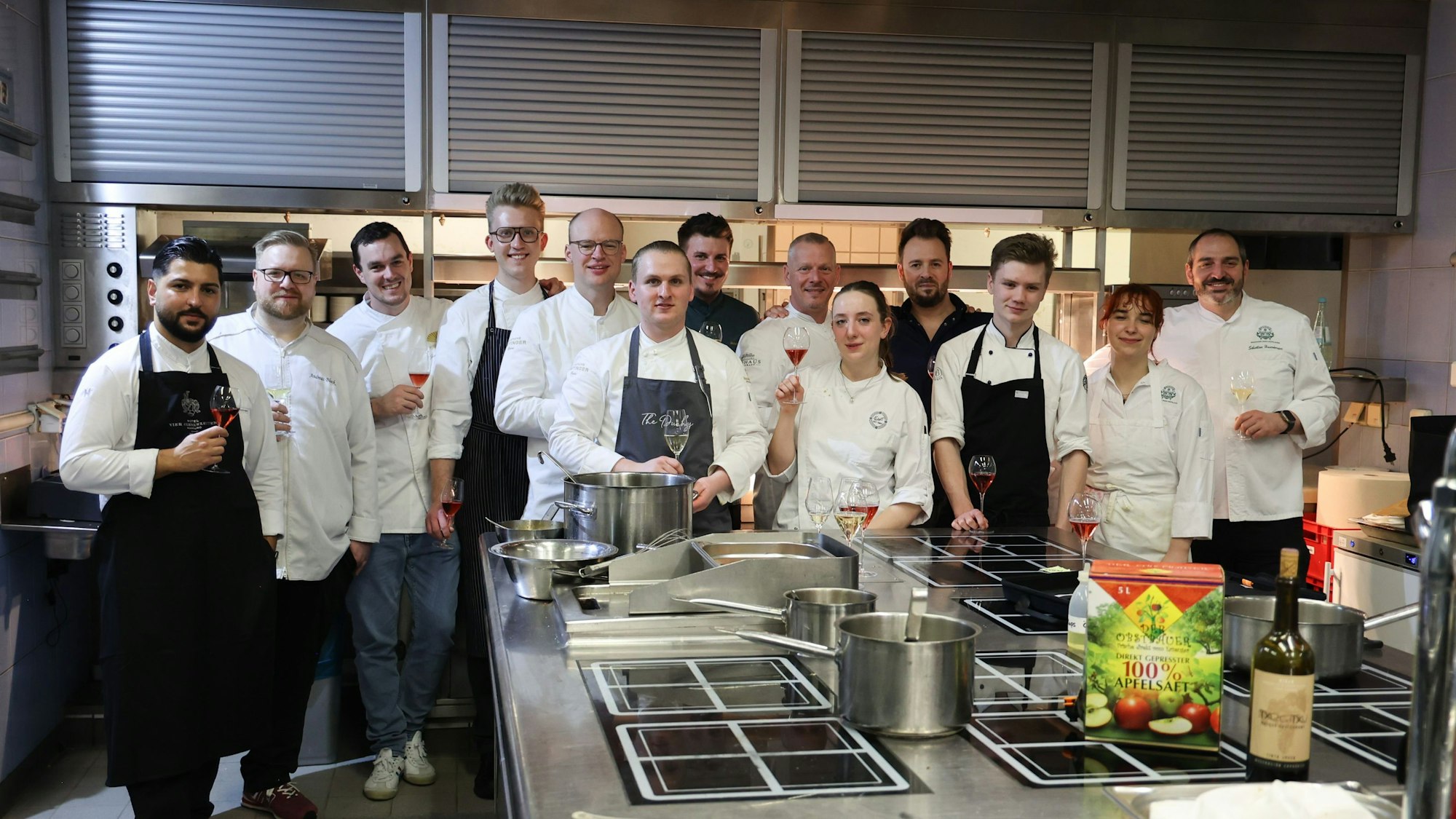 Die Auszubildenden und die Küchenchefs stehen in der Excelsior-Küche.