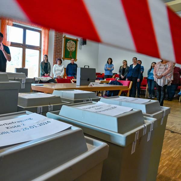 Mitarbeiter der Gemeinde Grünheide warten auf den Beginn der Auszählung der Briefwahl der Bürgerbefragung zur Tesla-Erweiterung.