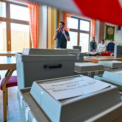 Mitarbeiter der Gemeinde Grünheide warten auf den Beginn der Auszählung der Briefwahl der Bürgerbefragung zur Tesla-Erweiterung.