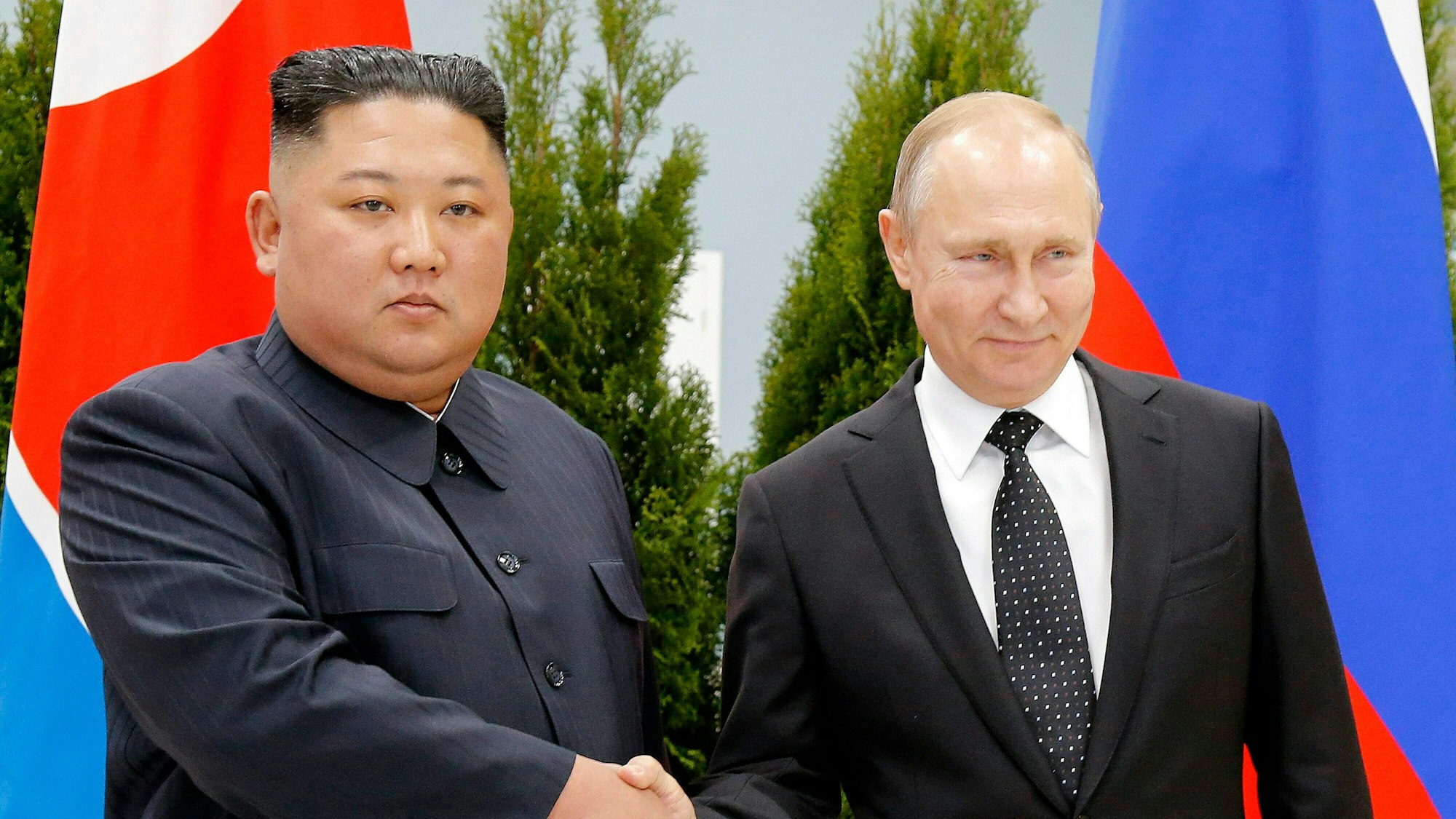 Wladimir Putin (r), Präsident von Russland, und Kim Jong Un, Machthaber von Nordkorea, geben sich während ihres Treffens die Hand.