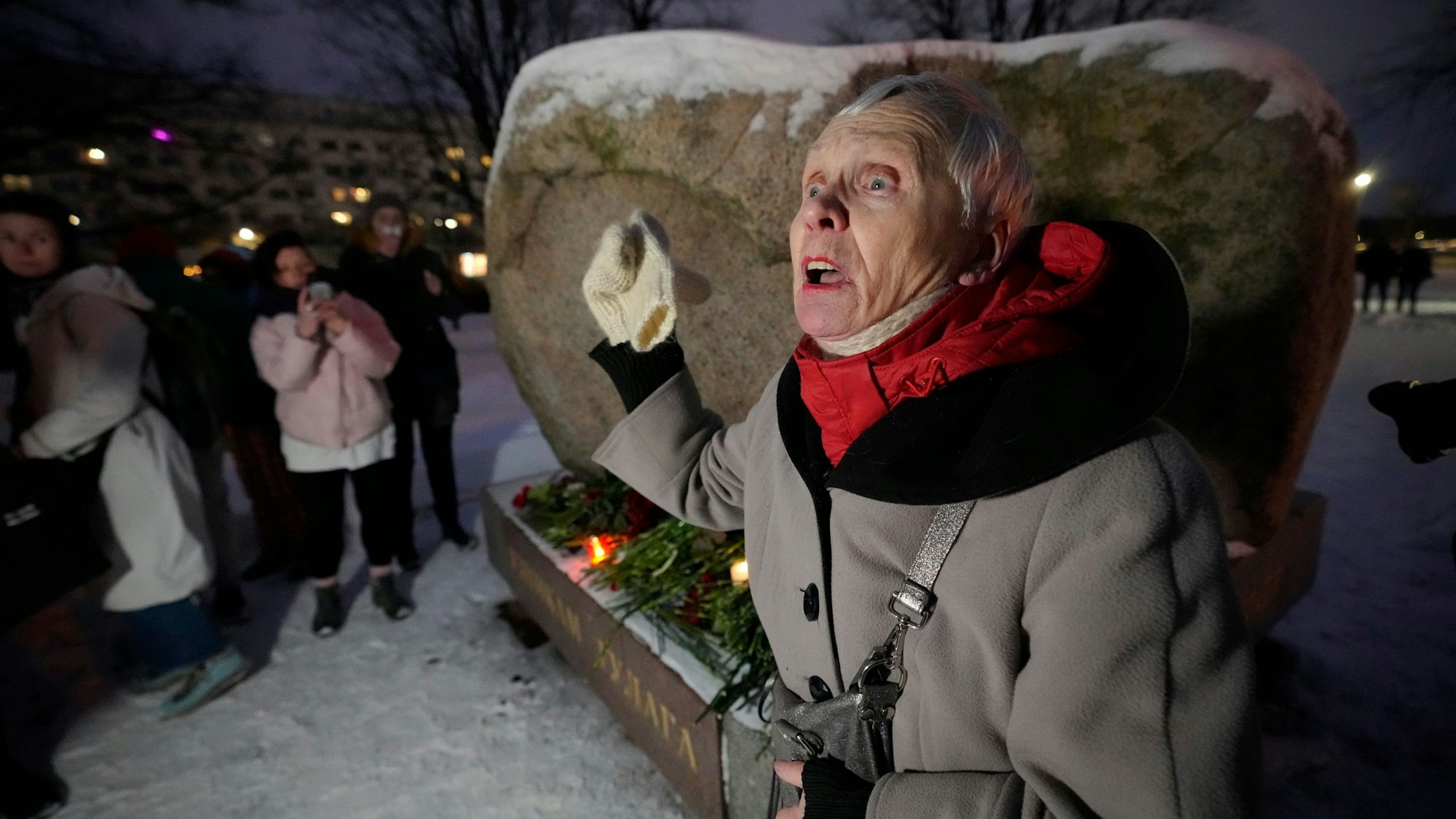 Eine Frau wendet sich an die Menschen, die sich versammelt haben, um Blumen für den russischen Oppositionellen Nawalny an einem Denkmal in St. Petersburg niederzulegen. Die Wutrede der Russin wurde mittlerweile millionenfach angesehen.