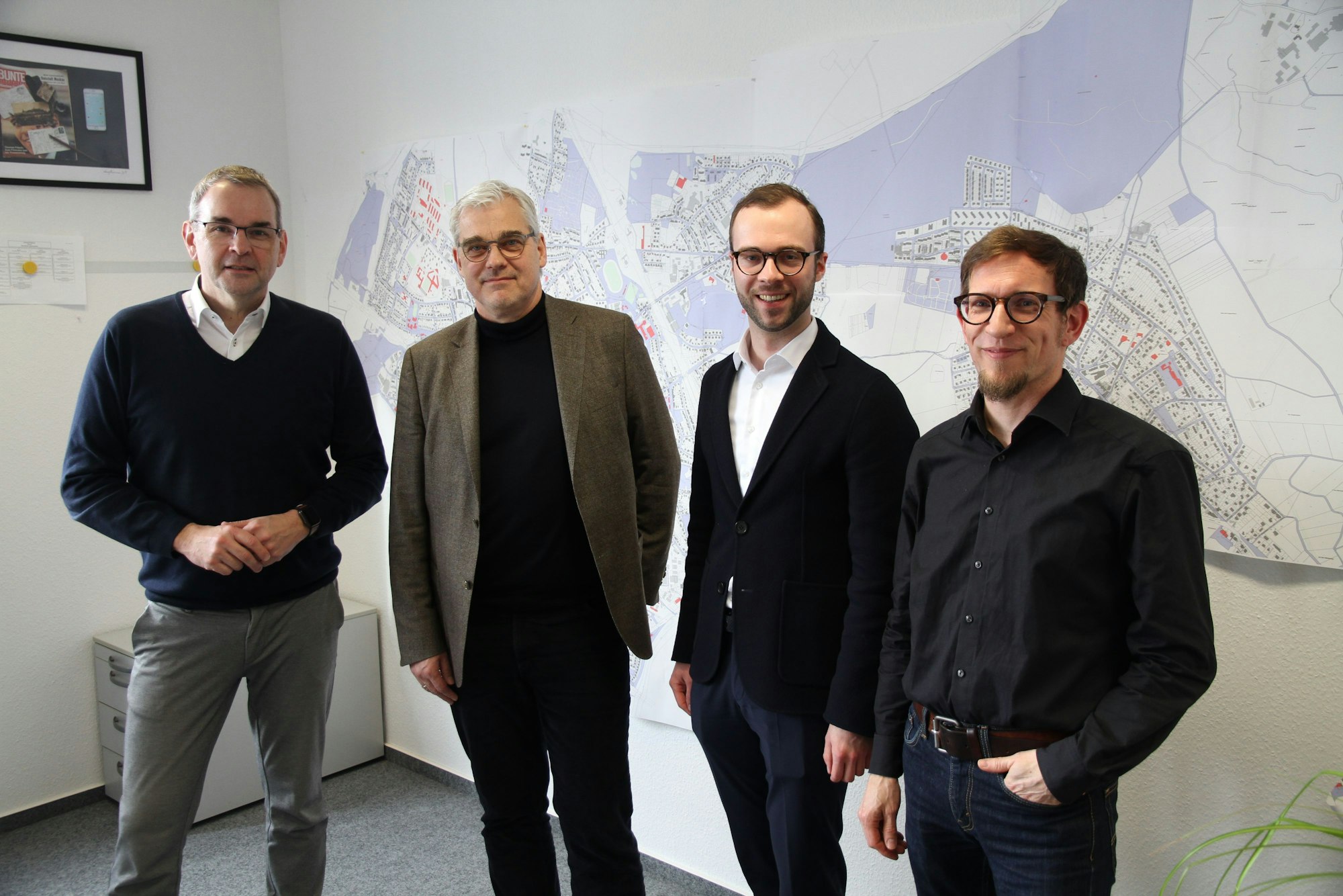 Vier Männer stehen vor einem Stadtplan