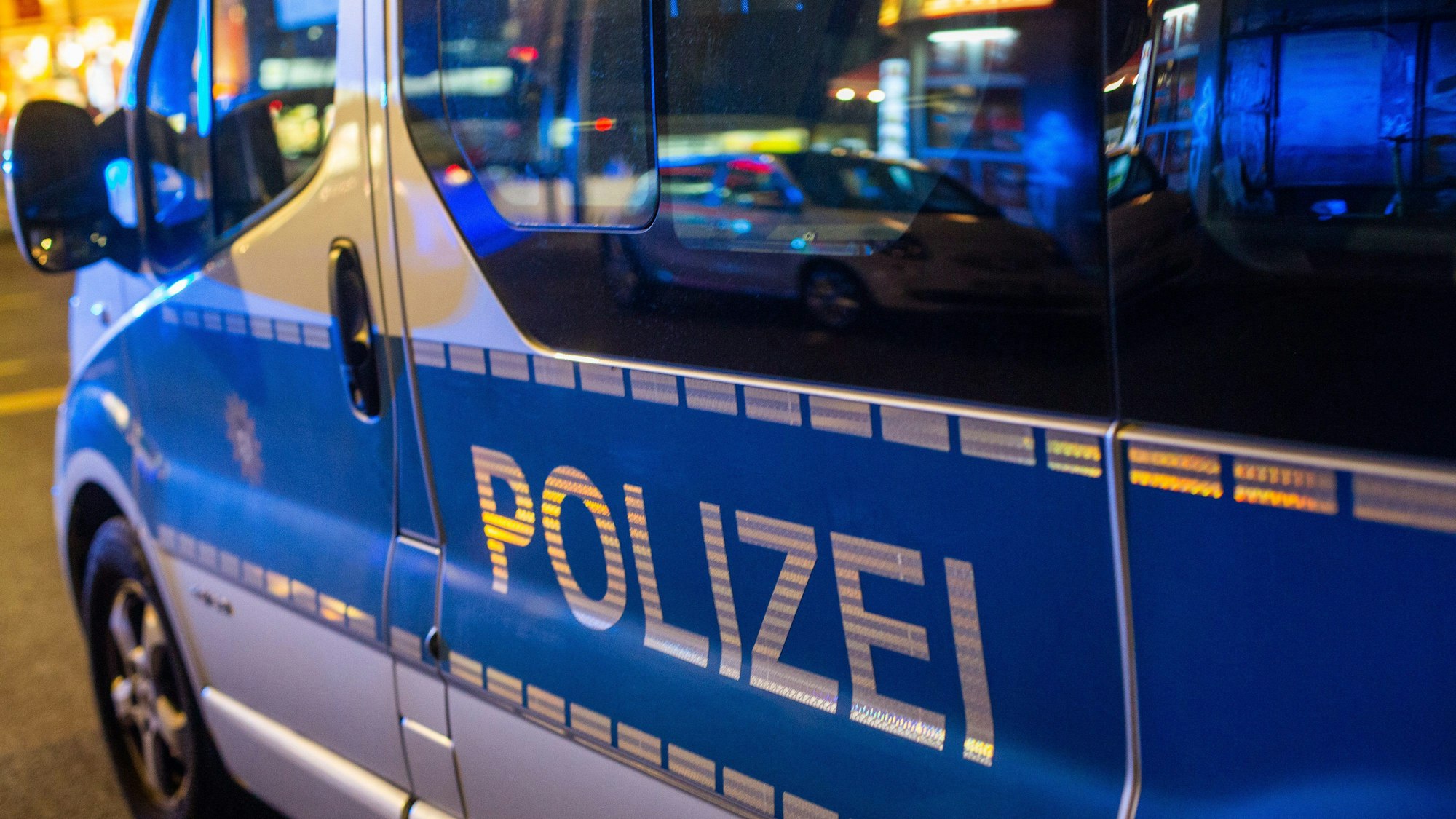 Ein Polizeifahrzeug steht bei einem Einsatz in der Nacht auf der Straße.