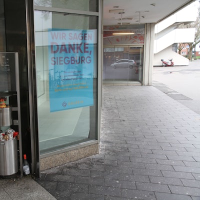 Ein überquellender Mülleimer neben dem Eingang eines geschlossenen Kaufhauses