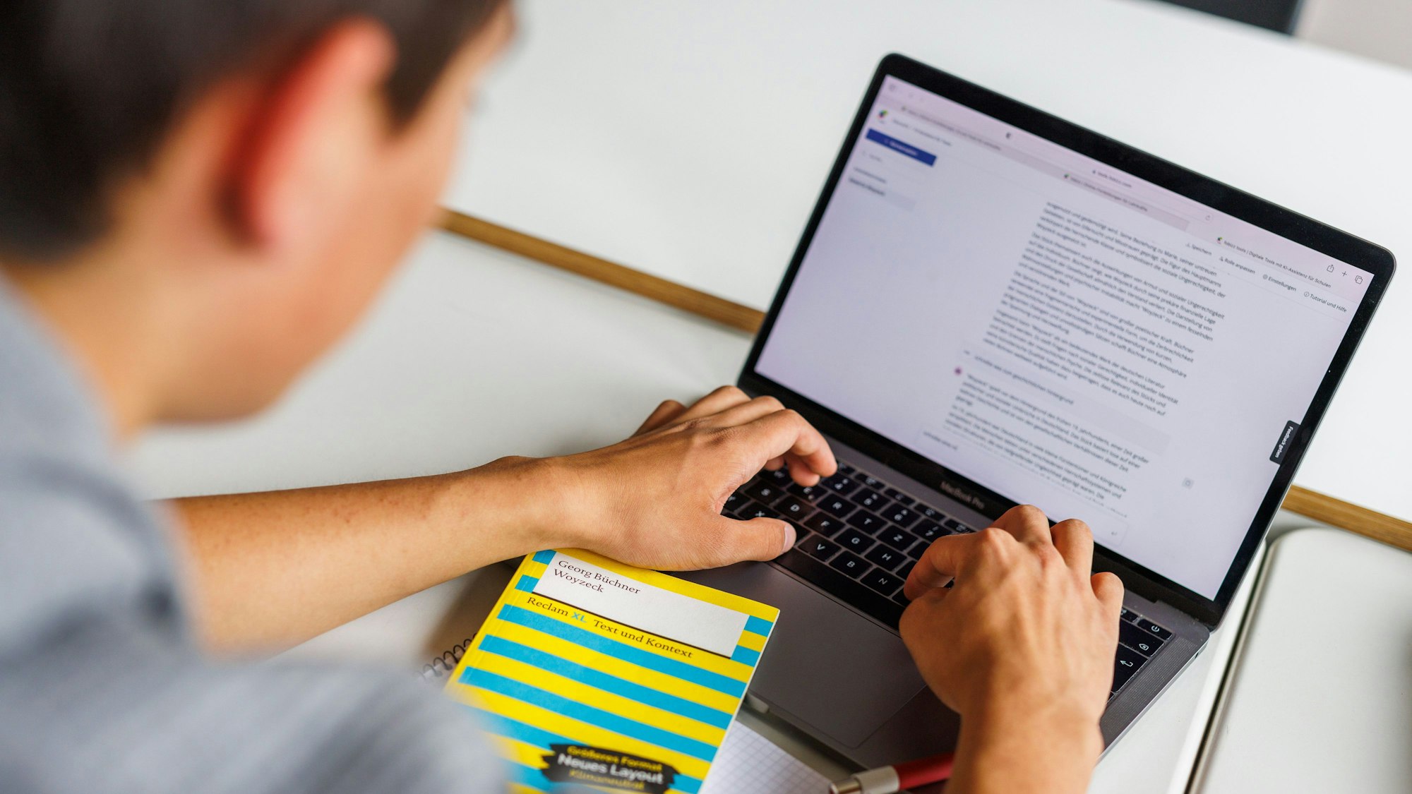 Ein Junge sitzt vor seinem Laptop.