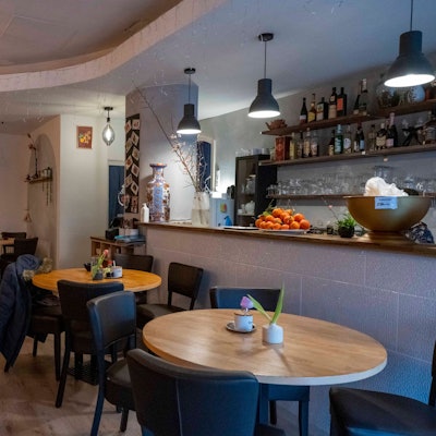 Runde Tische und gemütliche Stühle stehen im Innenraum des Restaurants Lai de Hao.