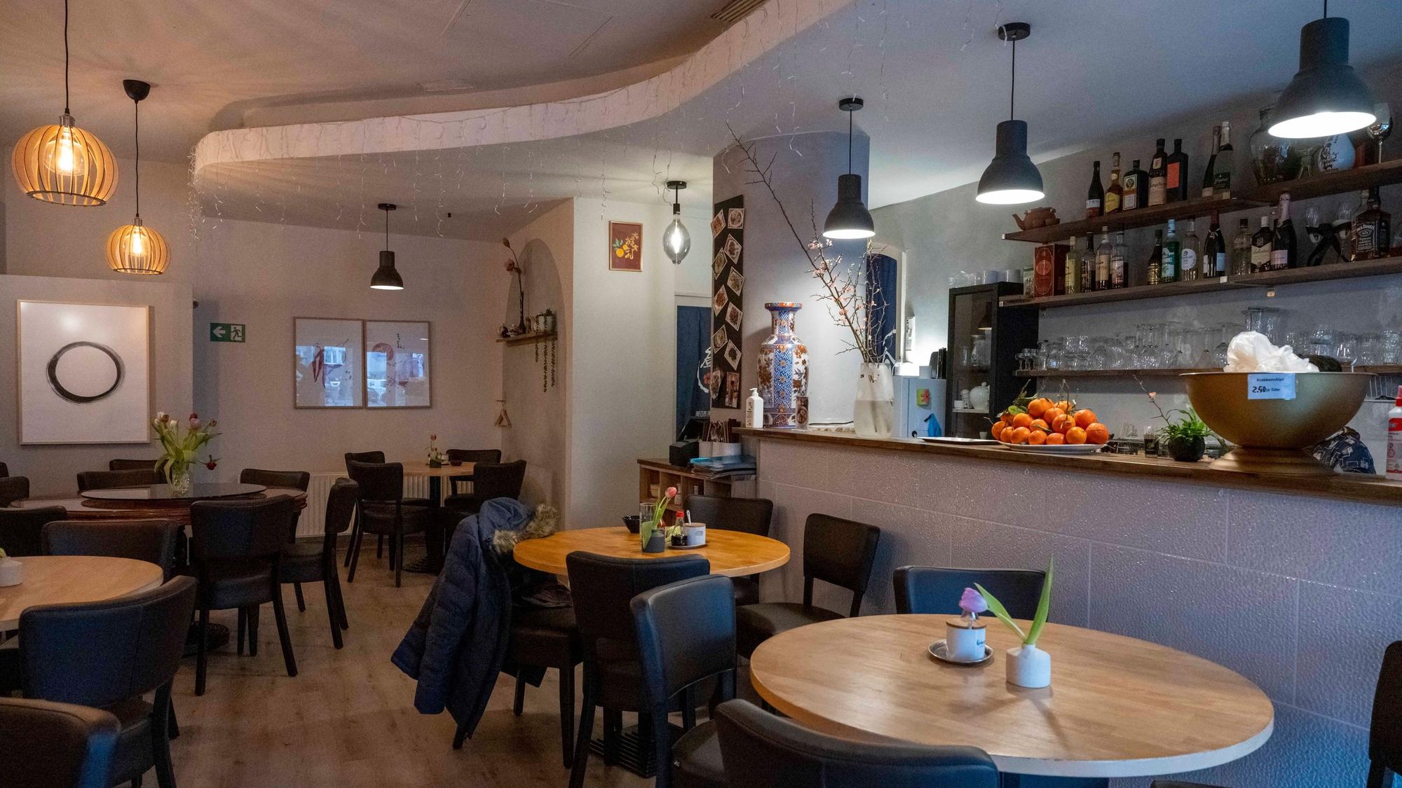 Runde Tische und gemütliche Stühle stehen im Innenraum des Restaurants Lai de Hao.